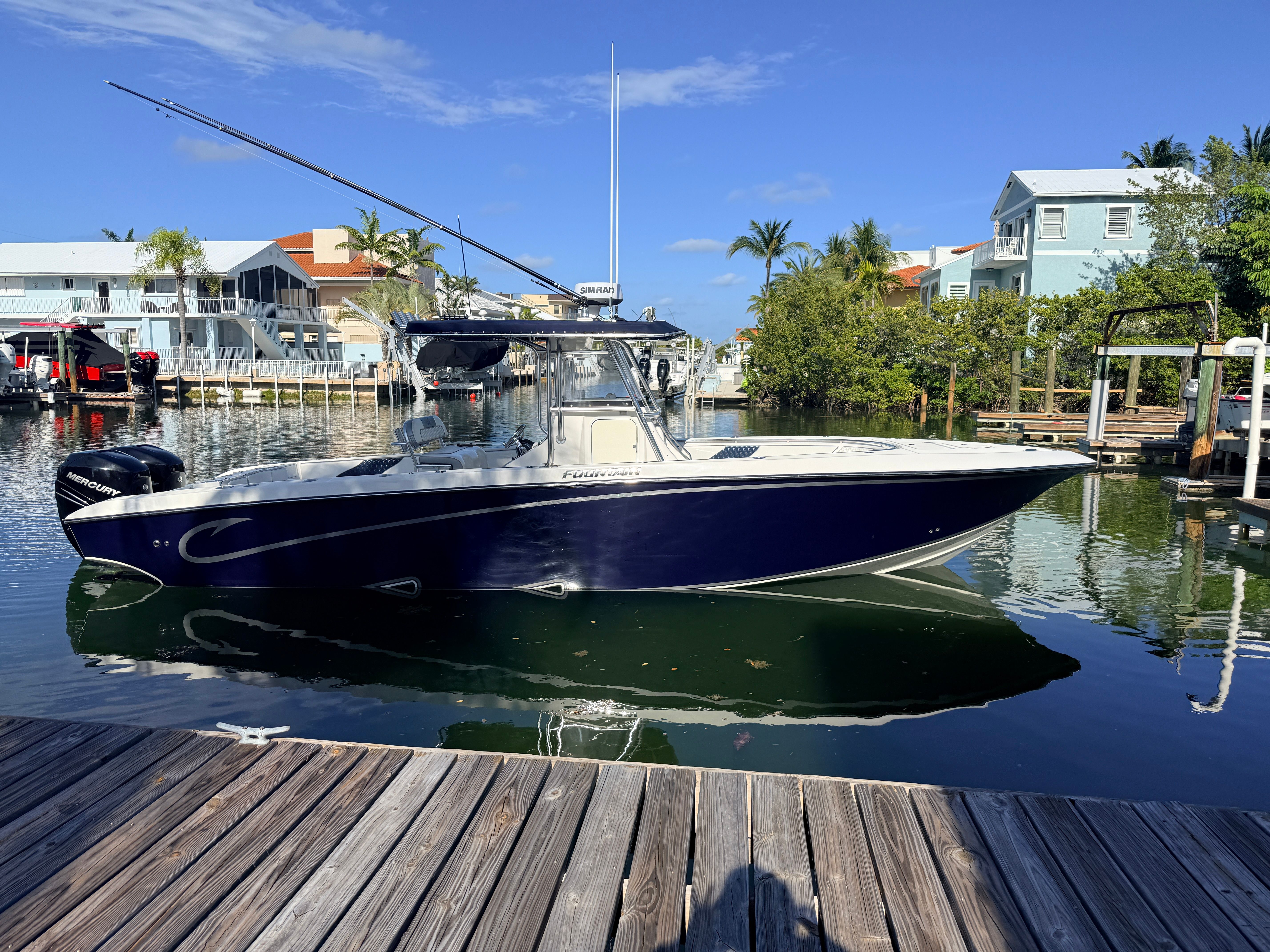 2007 Fountain 32 Center Console boat docked in harbor.