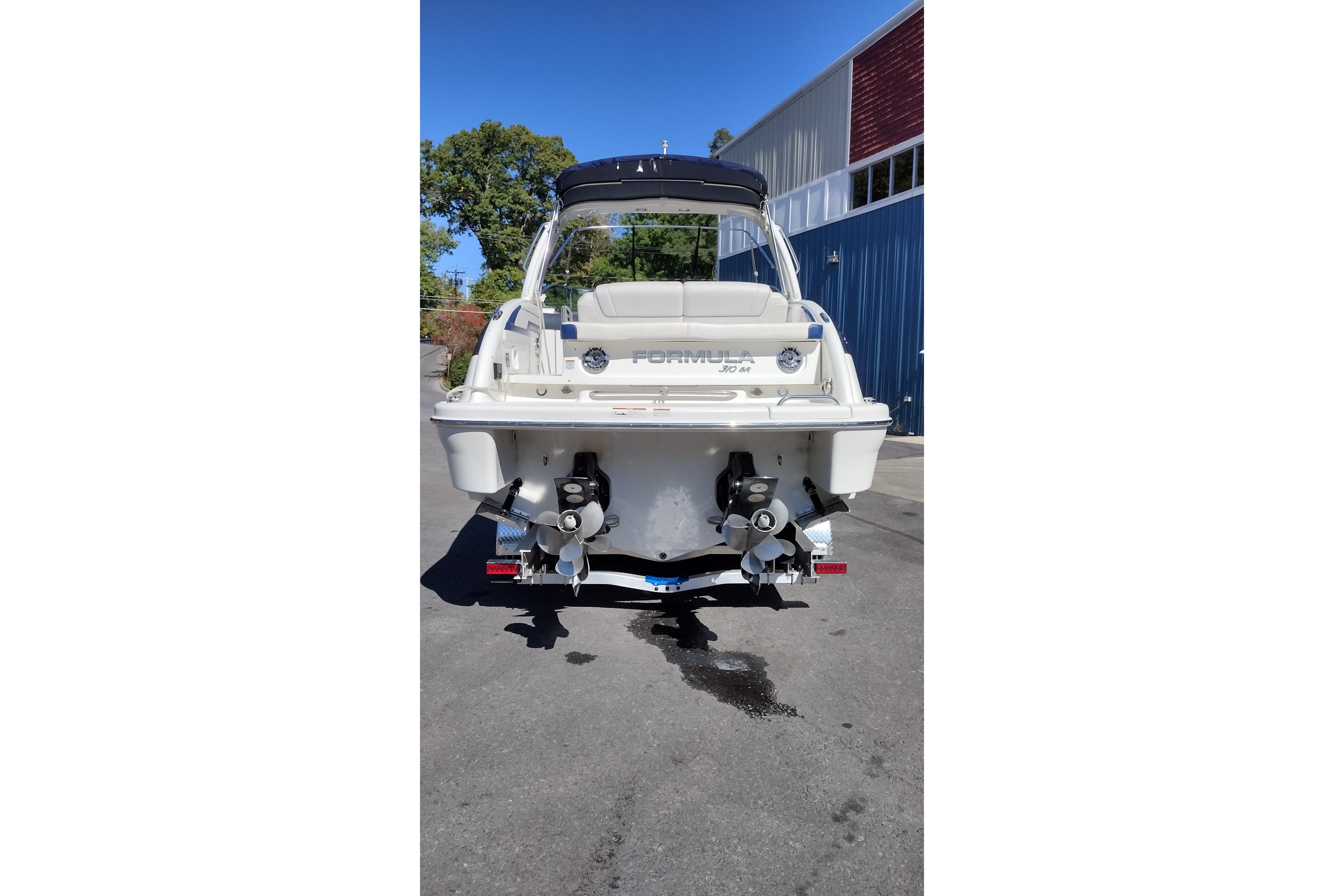 2022 Formula 310 Bowrider boat, rear view, parked outdoors on a sunny day.