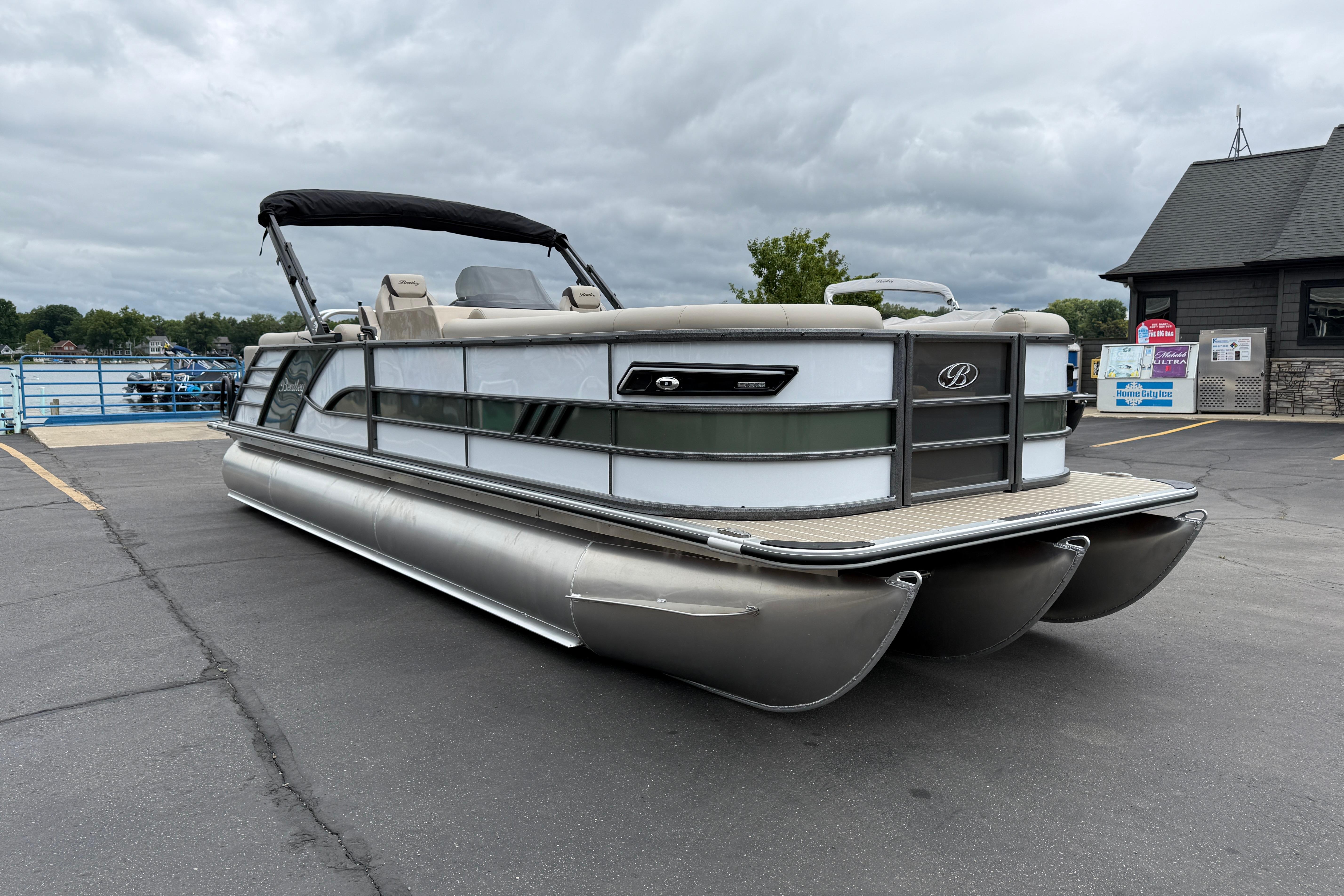 2026 Bentley Pontoons Elite 253 Admiral on a dock under cloudy skies.