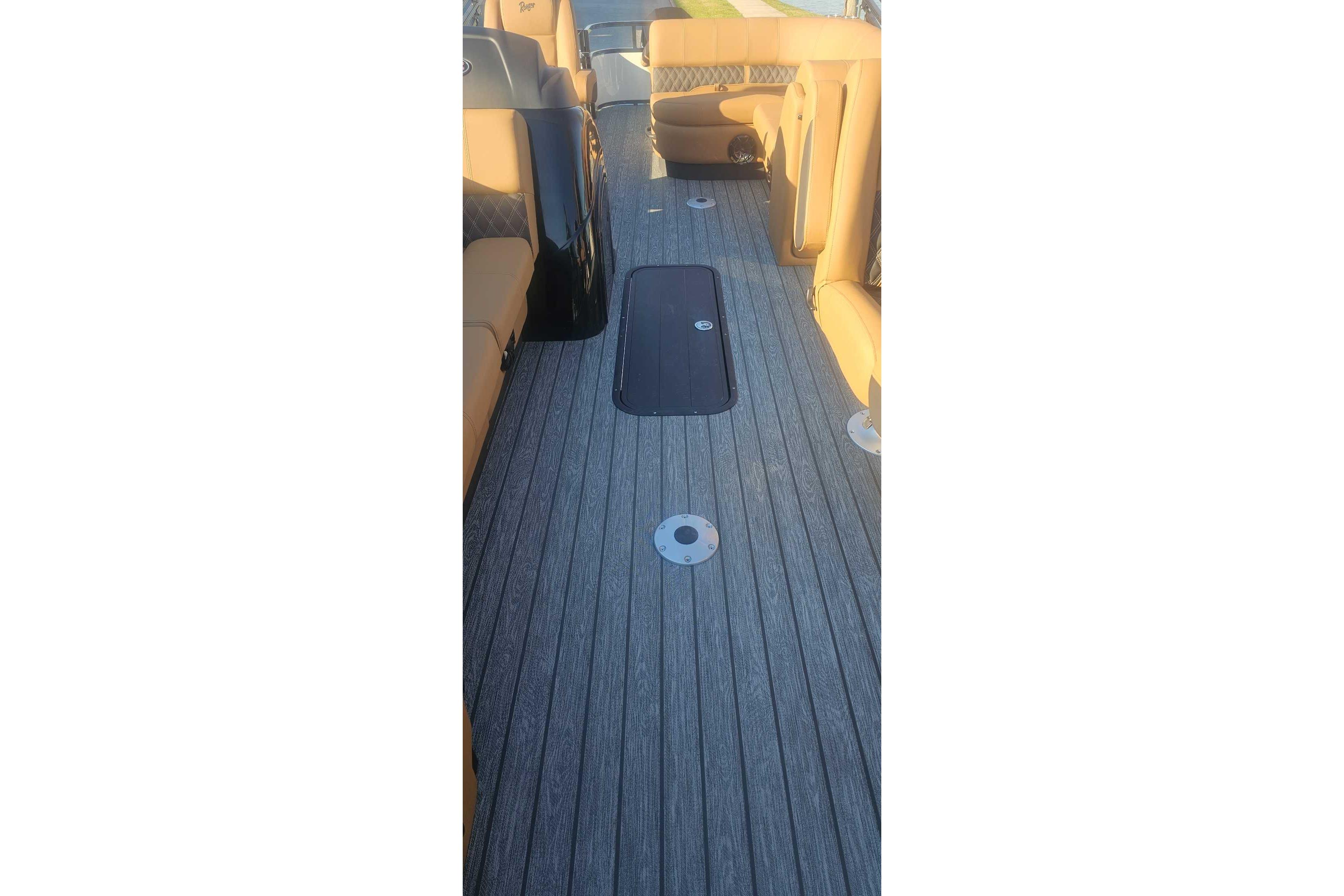 Interior view of 2026 Ranger 223FC boat with wood-textured flooring and tan seating.