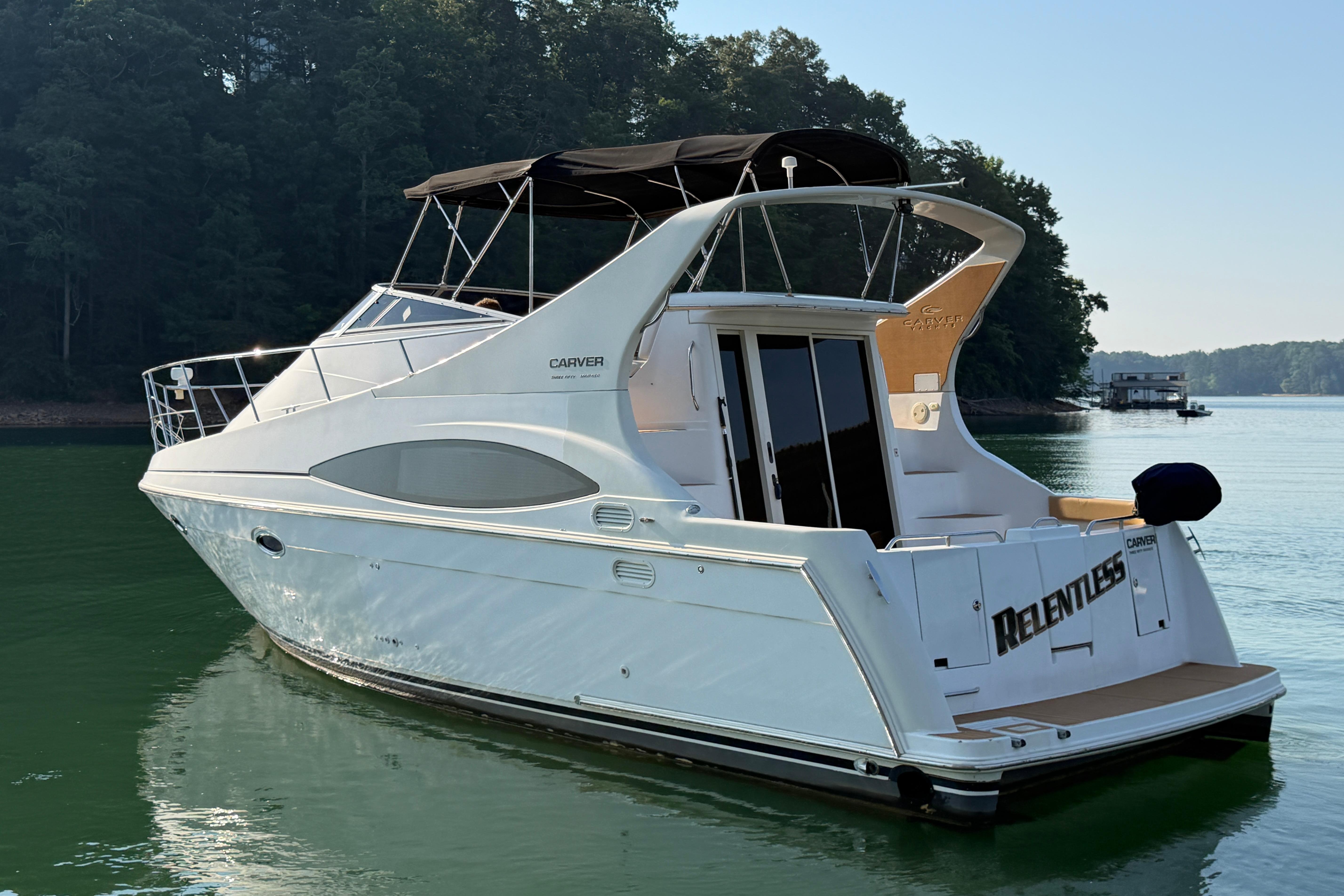 2003 Carver 350 Mariner yacht on calm water, surrounded by trees.