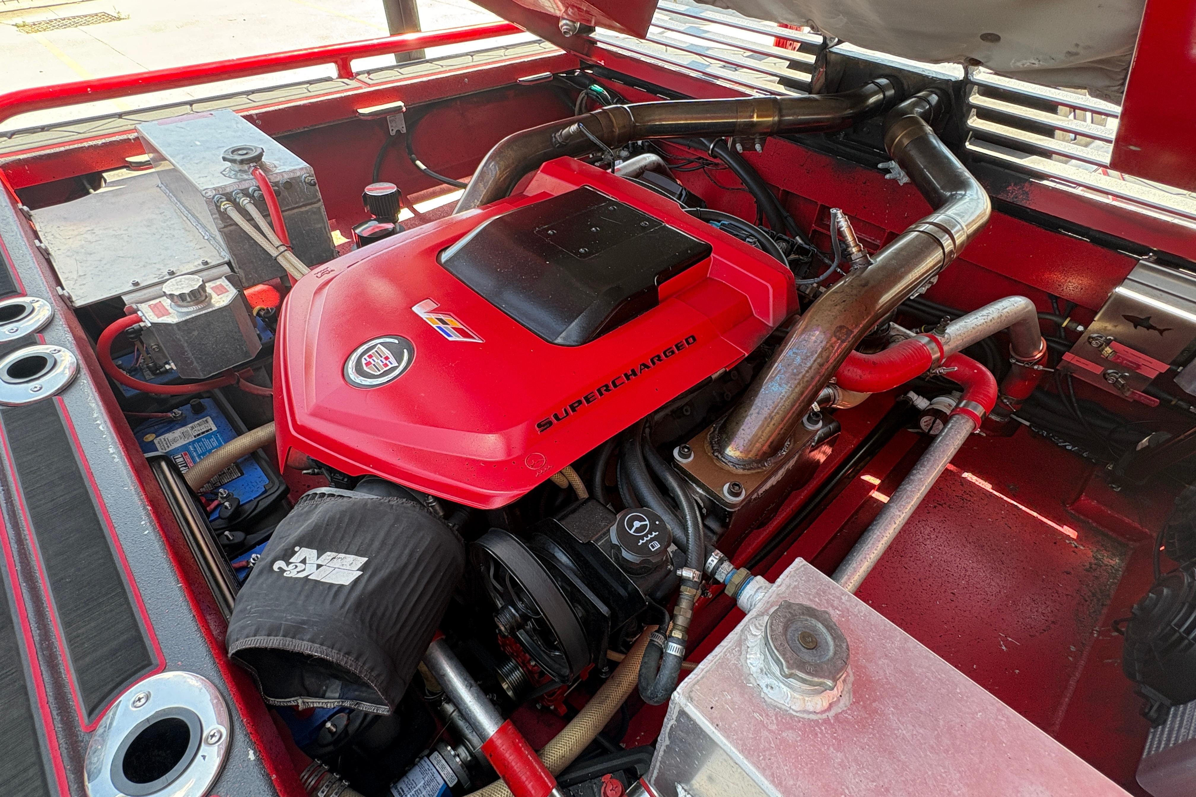 Supercharged engine of a 2018 Custom Swamp Shark 24' boat, featuring red components and intricate piping.