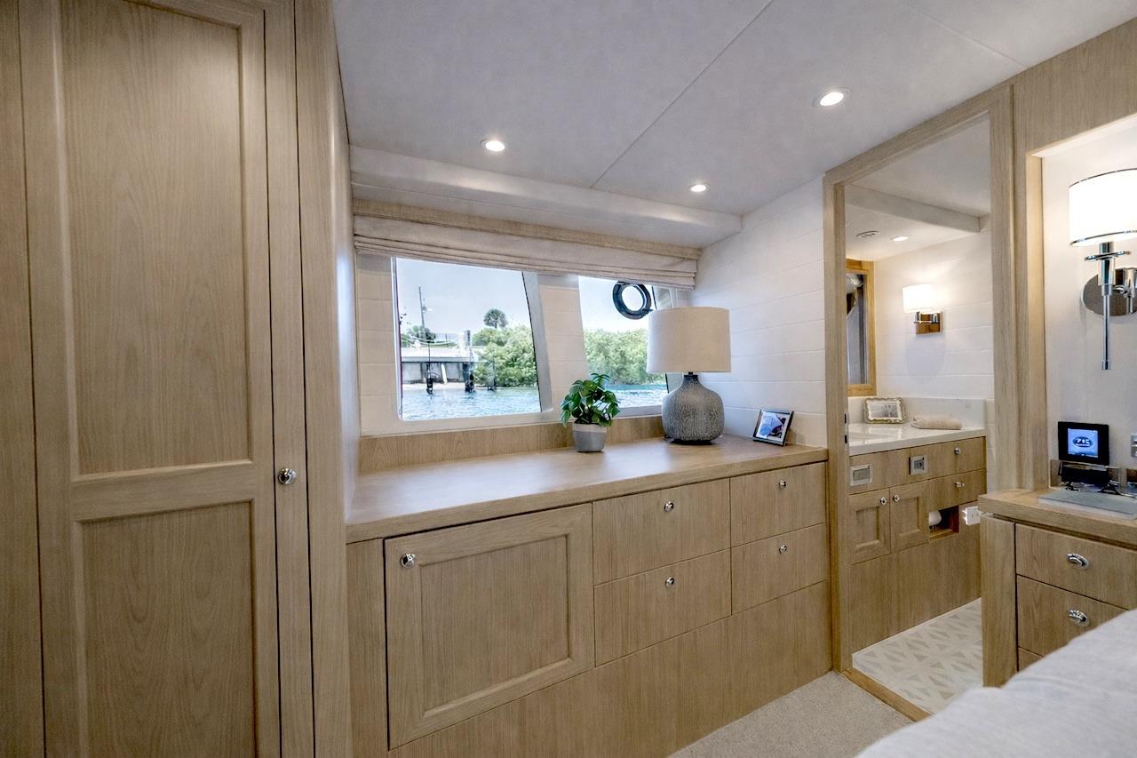 Luxurious interior of 2027 Offshore Yachts 70 CE, featuring elegant wood cabinetry and modern decor.