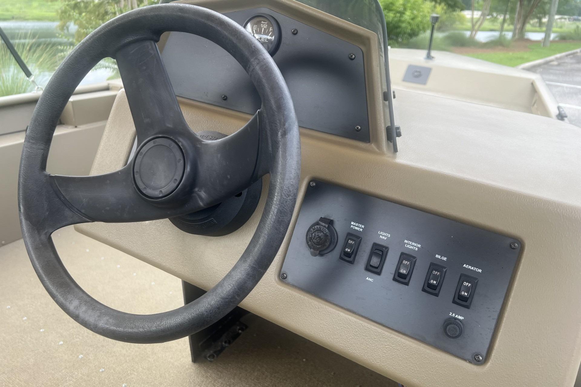 Steering wheel and control panel of 2016 G3 1756 SC boat, featuring switches and gauges.