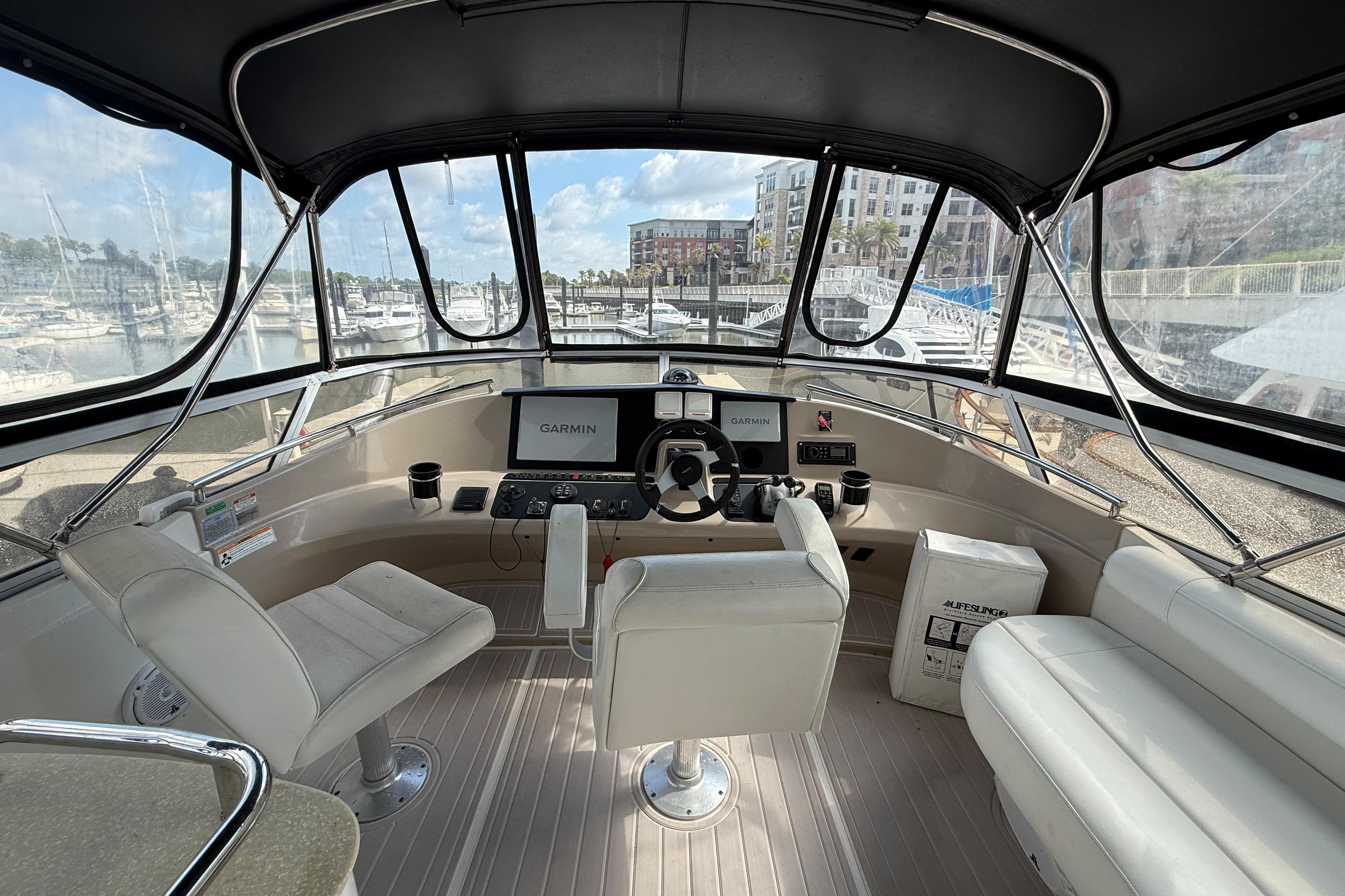 2006 Carver 43 Motor Yacht helm with Garmin navigation, marina view, and comfortable seating.