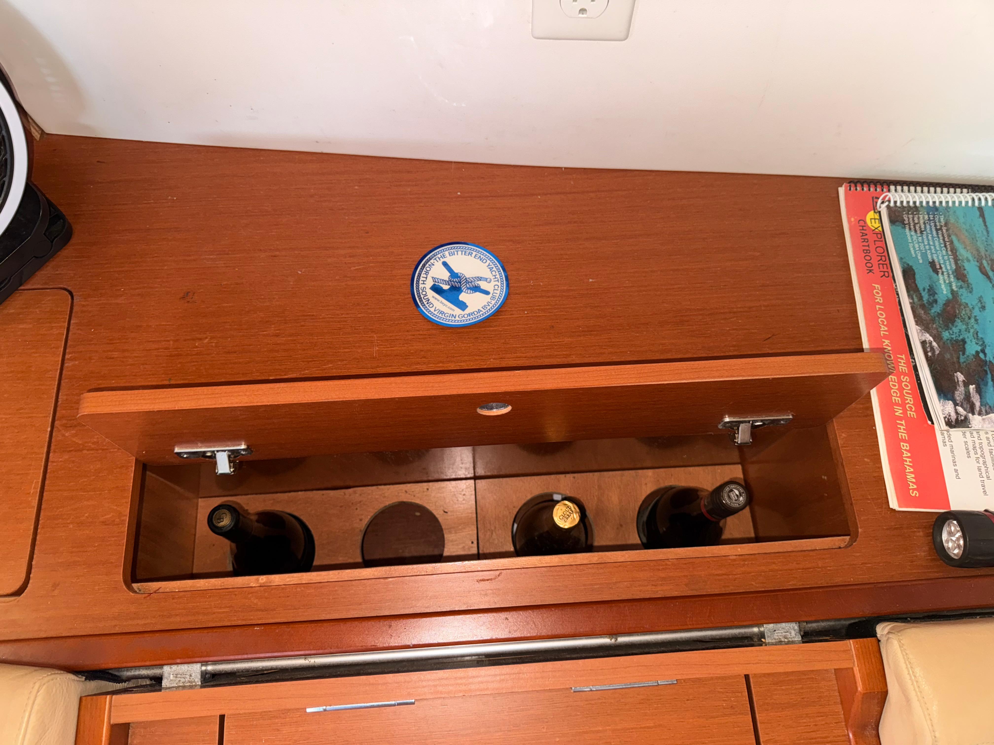 Wooden storage compartment on 2016 Beneteau Oceanis 45 yacht, holding wine bottles.