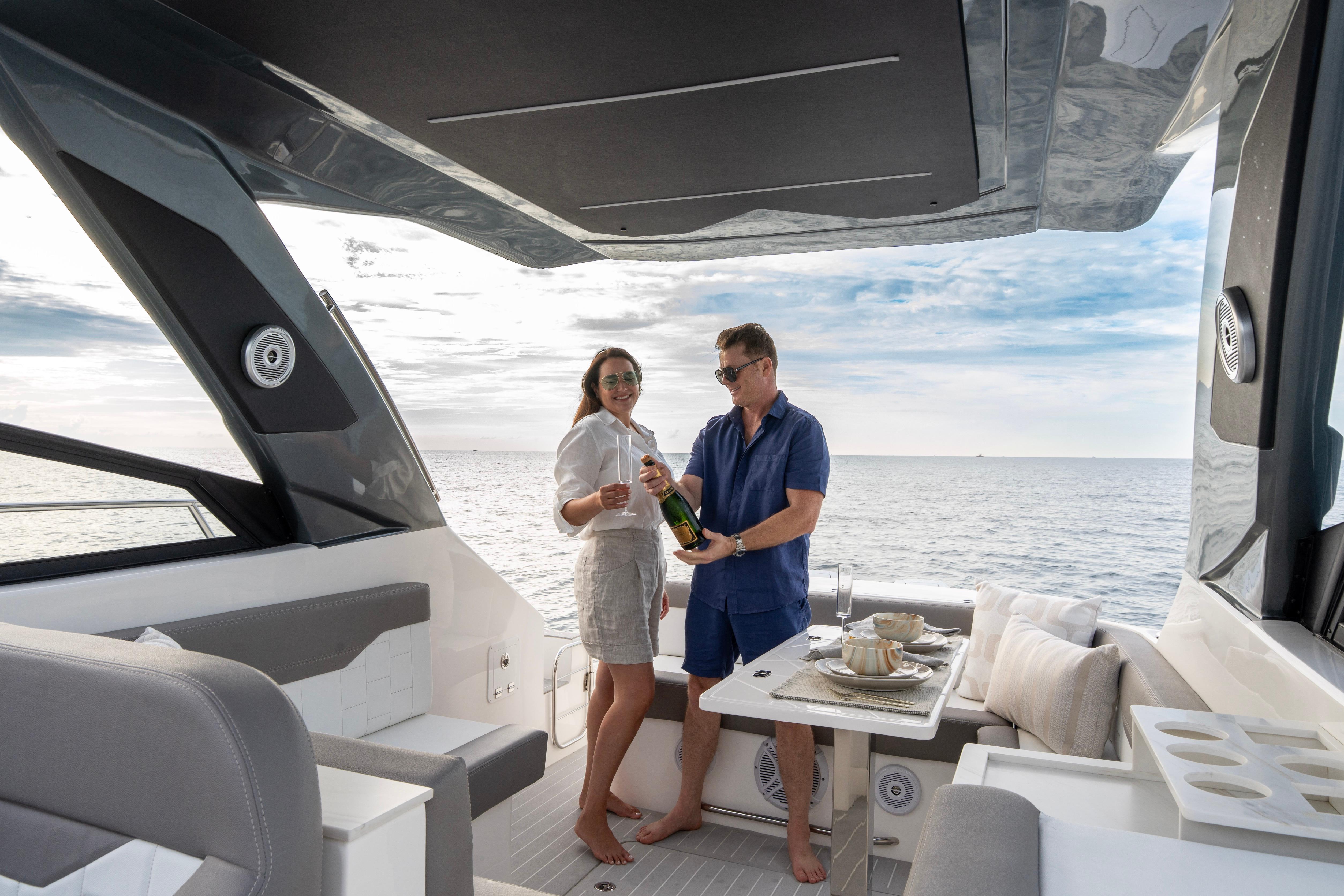 Couple enjoying champagne on a 2025 Valiatt 380GT yacht, with ocean view.
