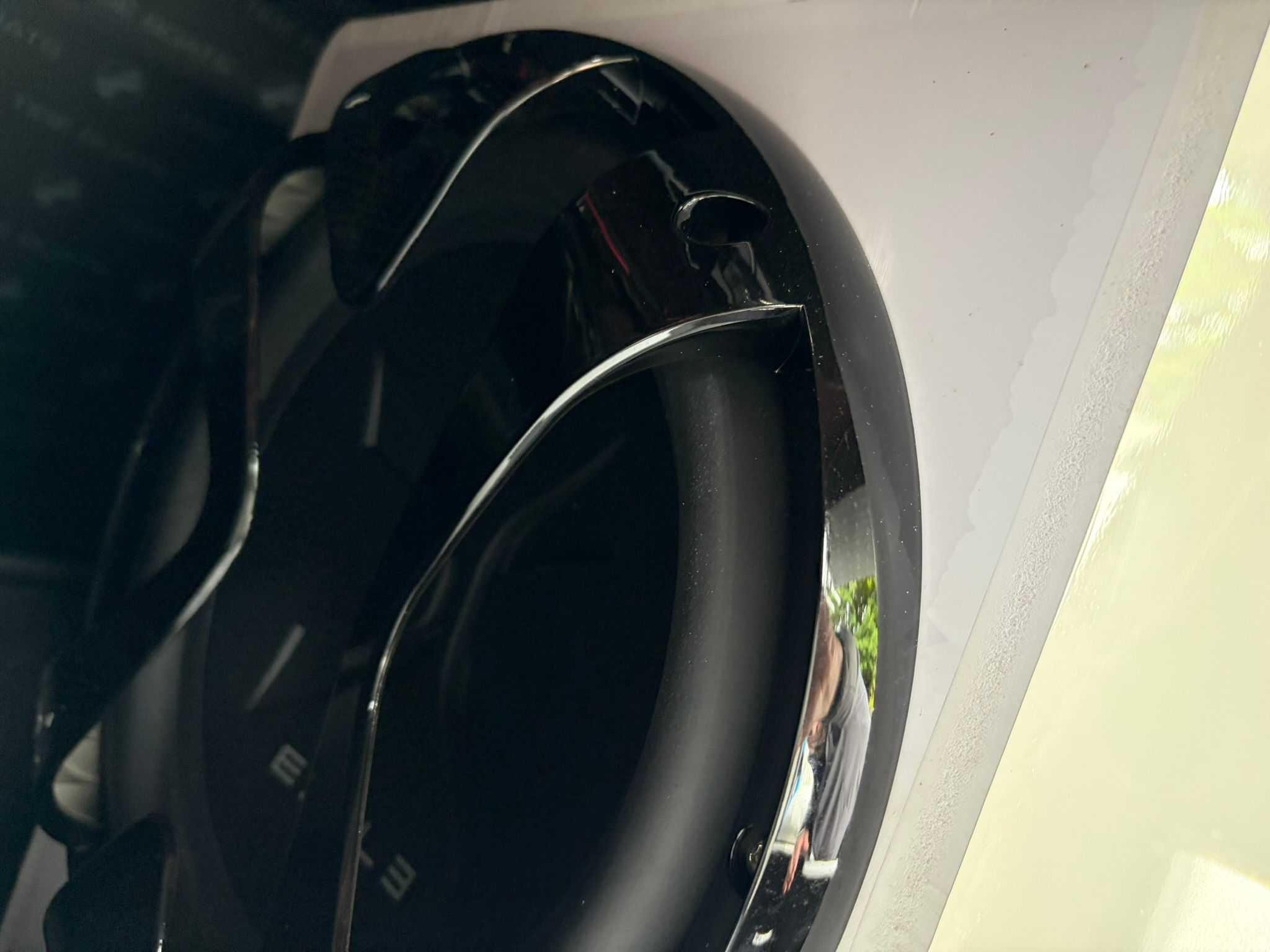 Close-up of a shiny black boat steering wheel.
