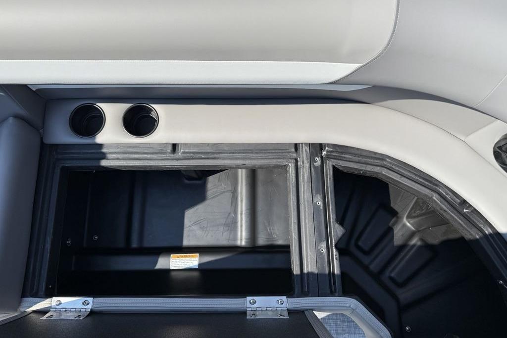 Interior storage compartment of 2026 Premier 220 Sunscape RF boat with cup holders.