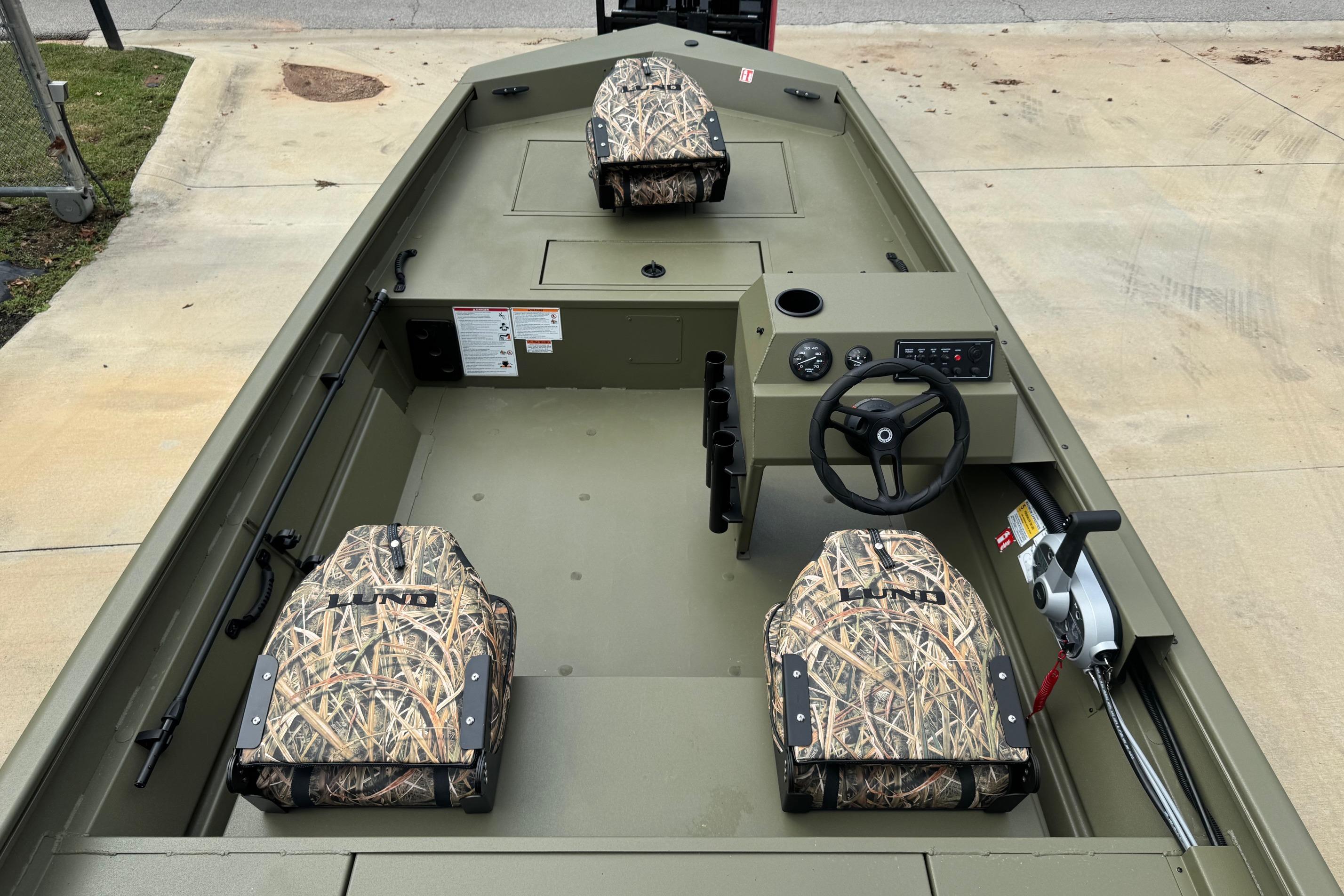 2026 Lund 1760 Predator SC boat interior with camo seats and steering console.