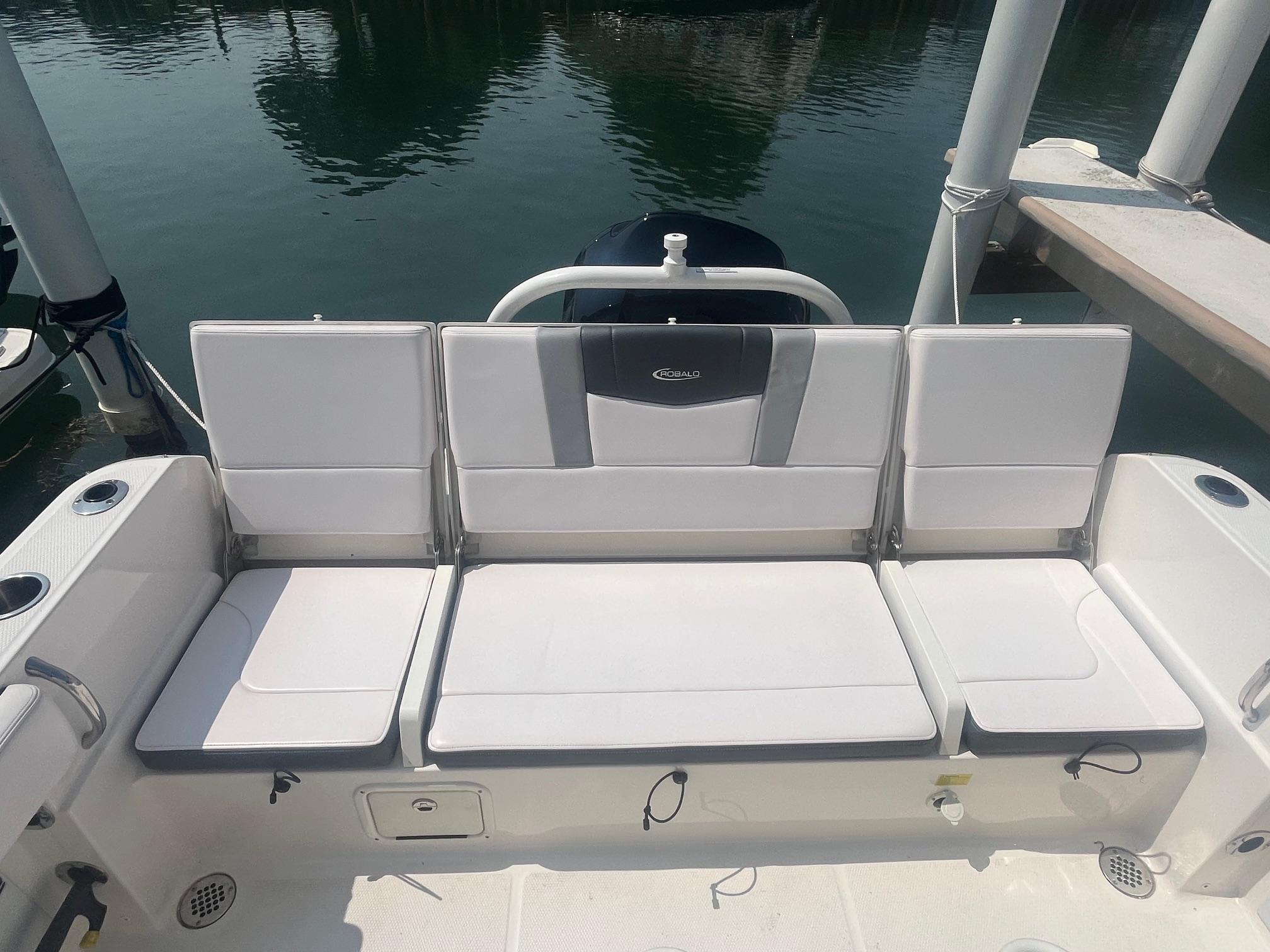 2020 Robalo R230 Center Console boat seating area with white cushions and cup holders.