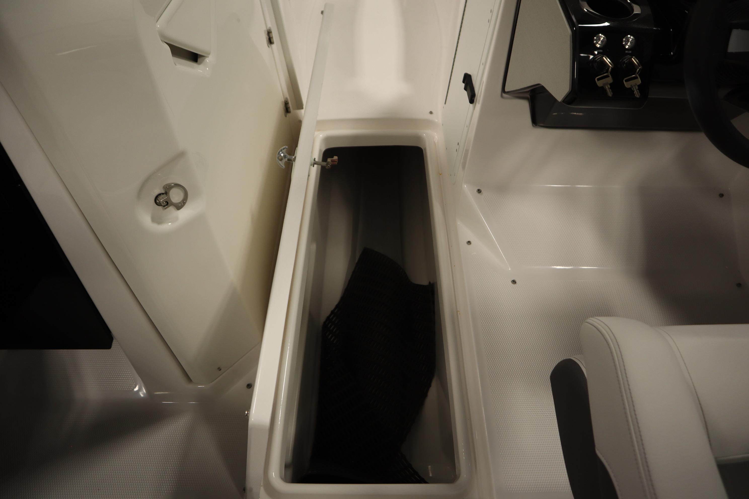 2026 Yamaha Boats AR250 interior storage compartment with open hatch and seating area.