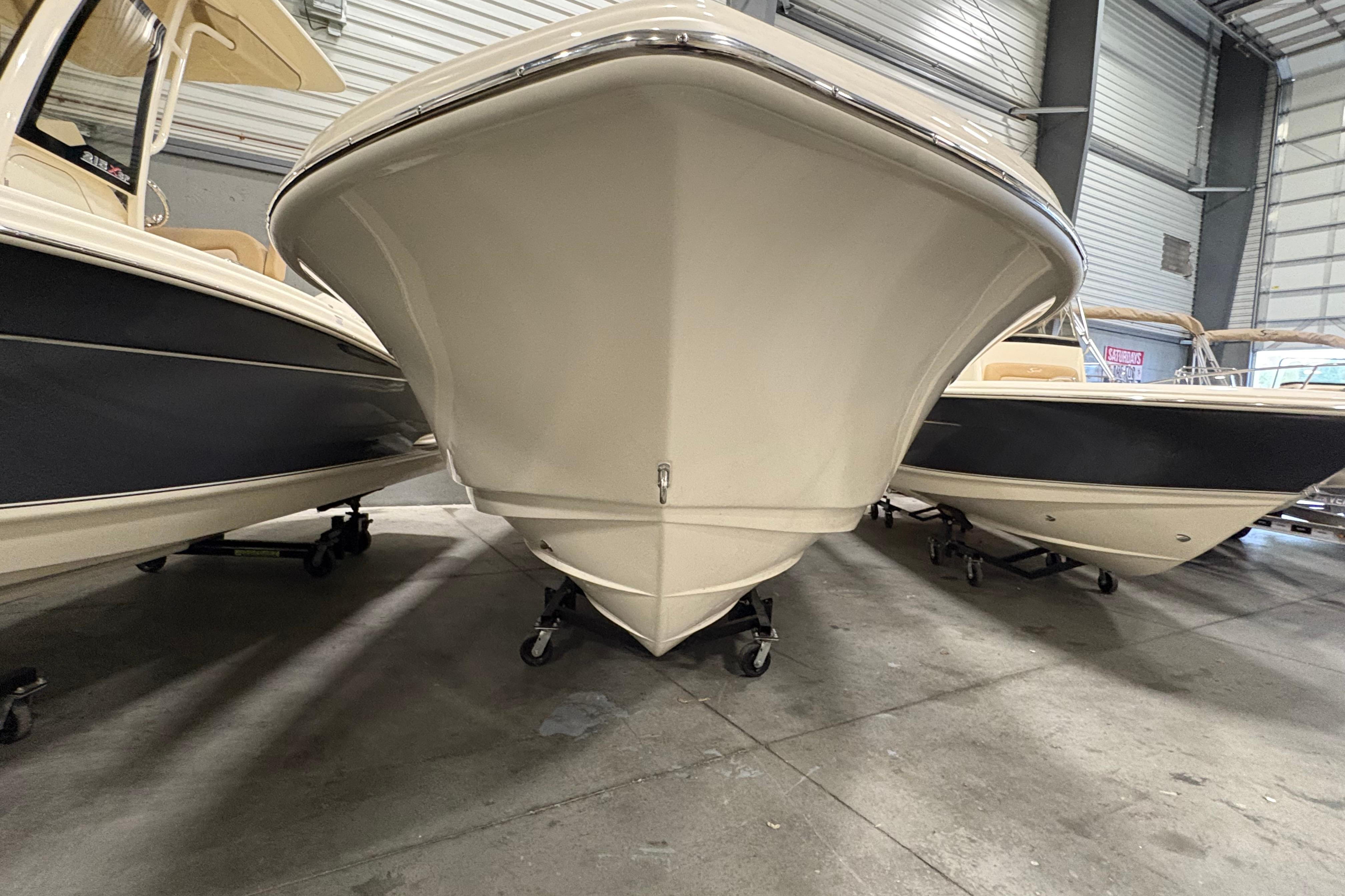2025 Scout 215 XSF boat in showroom, front view, surrounded by other boats.