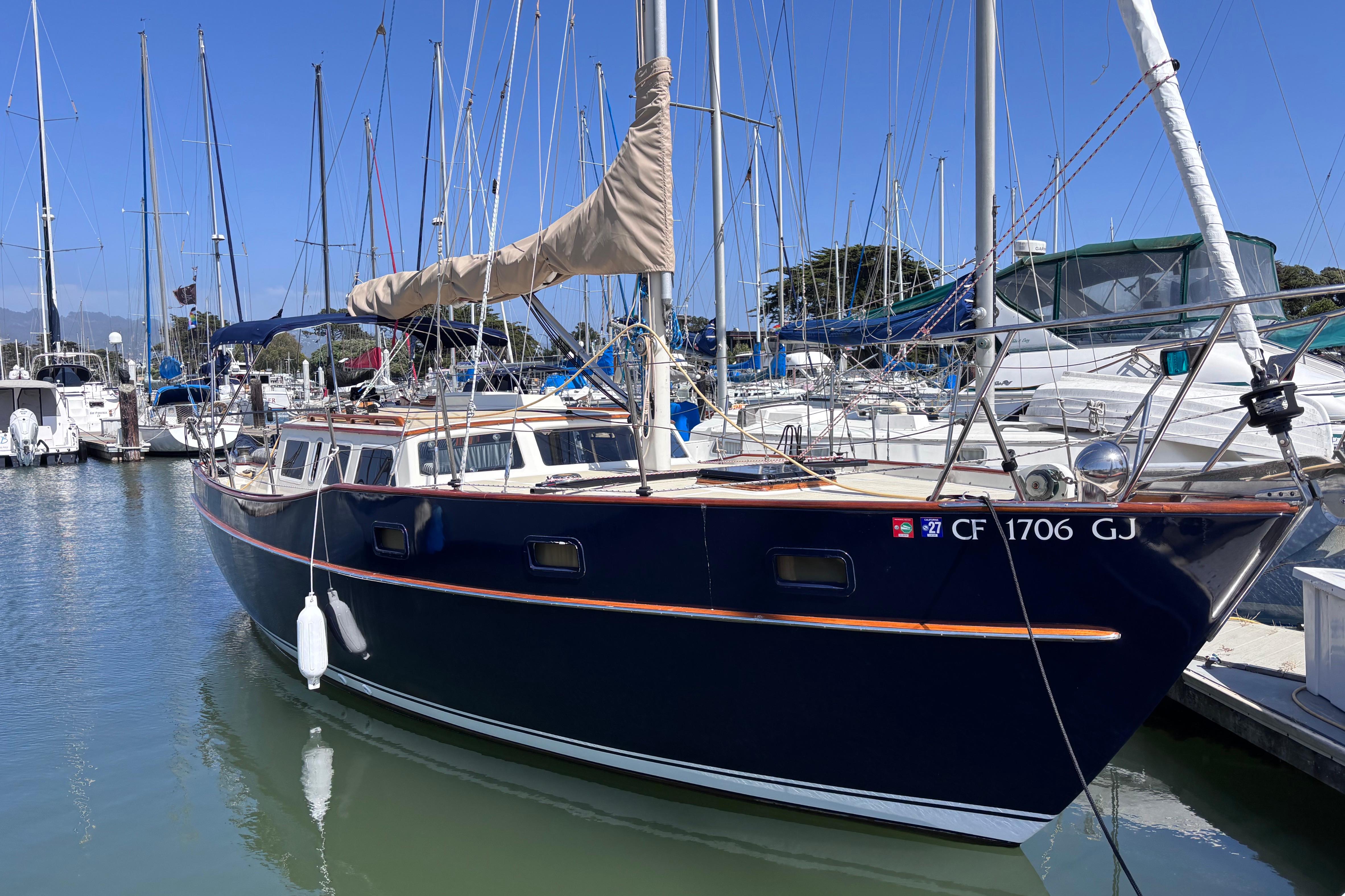 1978 Swift 33 sailboat docked in a marina under clear blue skies.