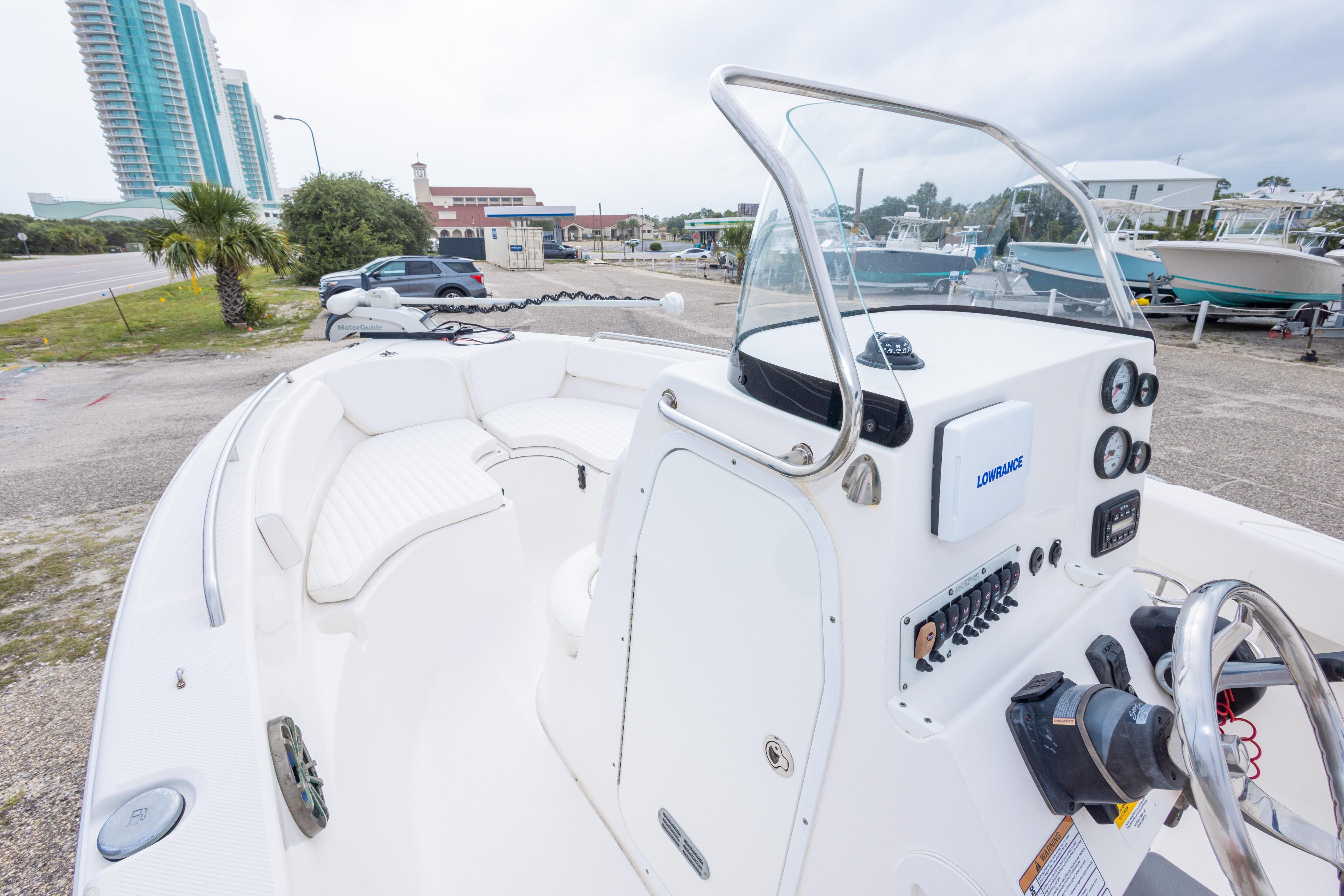2014 Sea Fox 209 Commander boat interior with steering console and seating, docked near buildings.