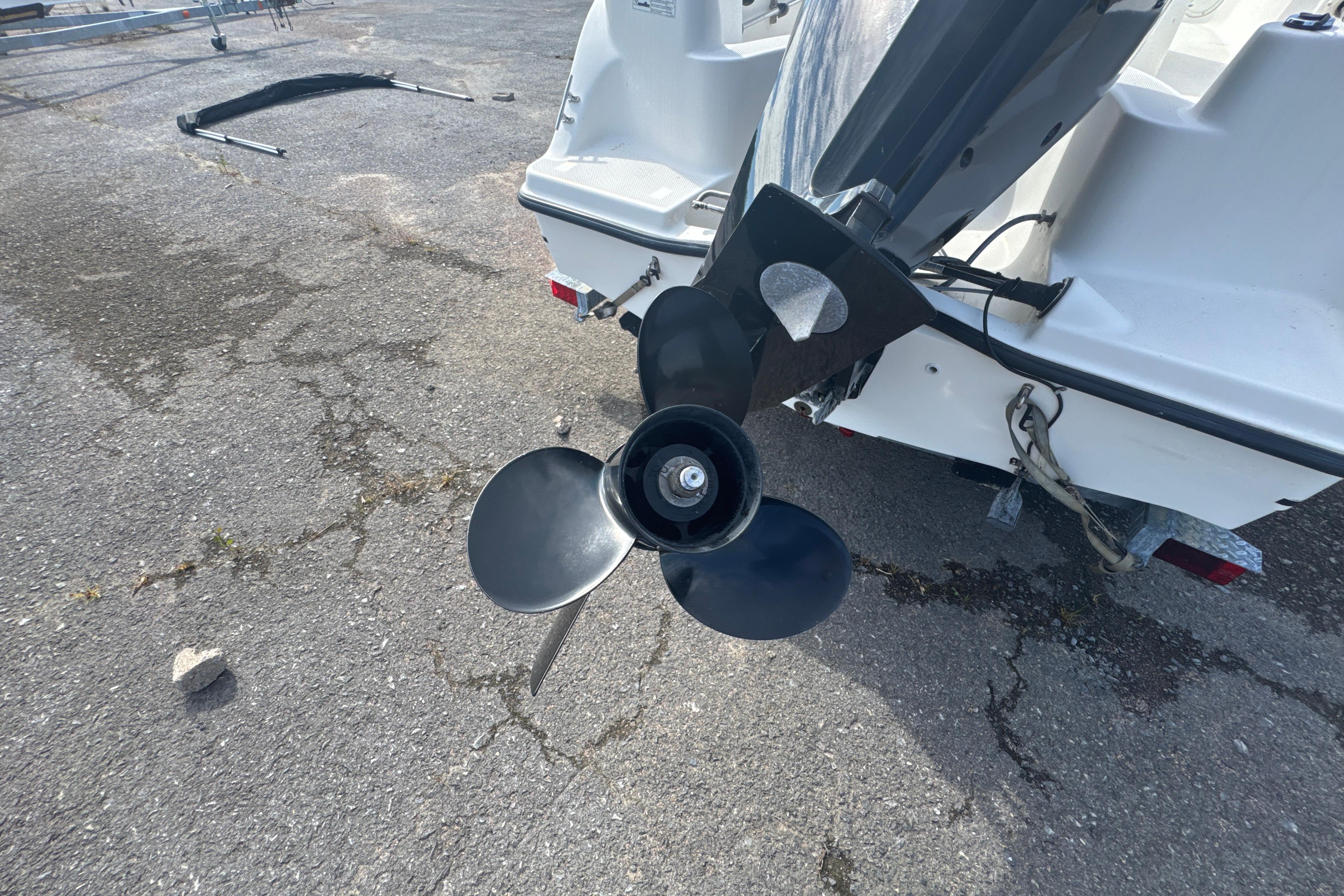Rear view of a 2007 Trophy 1703 Center Console boat propeller on pavement.