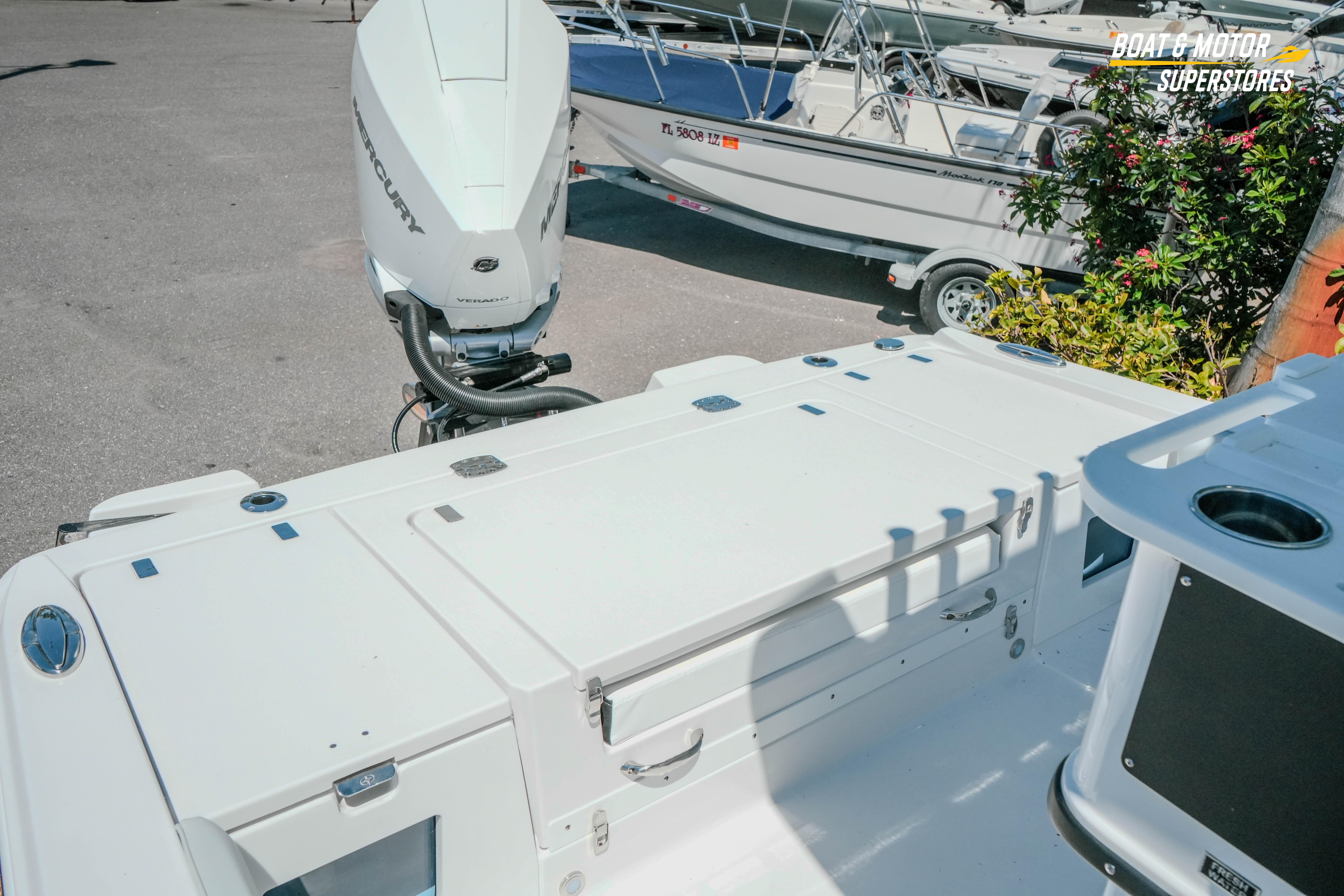 2026 Blackfin 242 HB boat with Mercury engine, parked at a dealership.