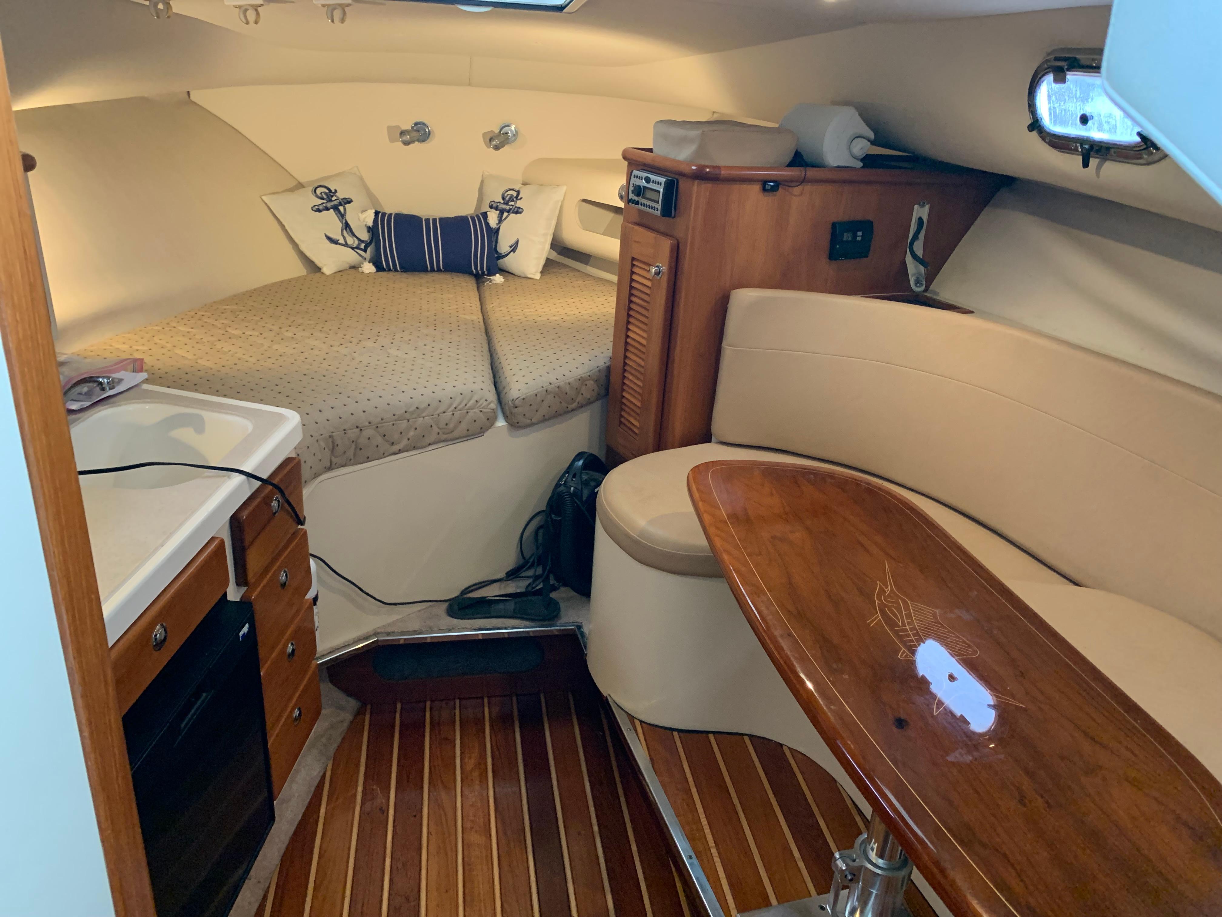 2007 Pursuit OS 335 cabin interior with cozy seating and wooden table.