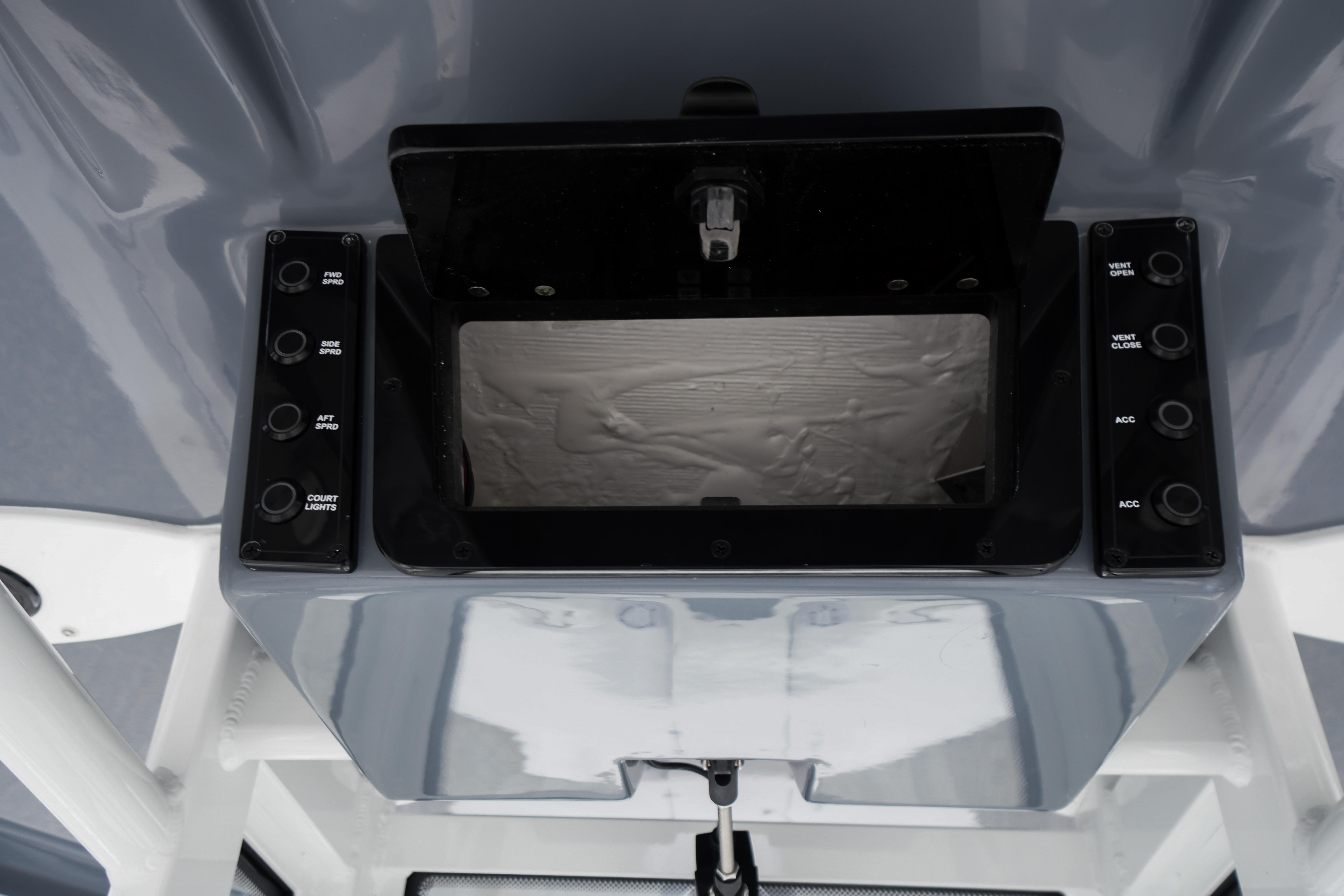 Control panel of 2026 Tidewater 232 SS boat with various switches and compartments.