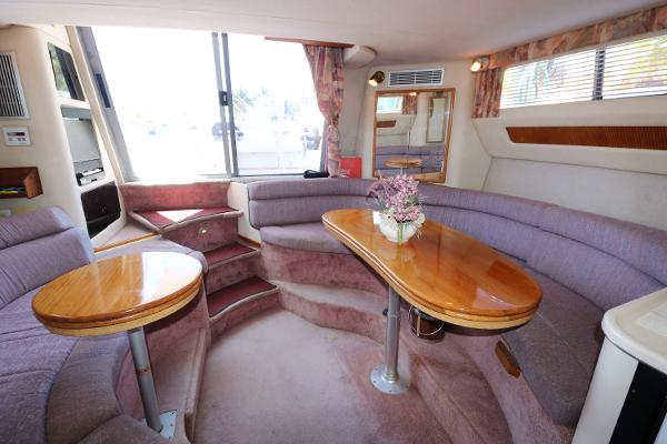 Interior of a 1992 Sea Ray 350 Express Bridge yacht with plush seating and wooden tables.