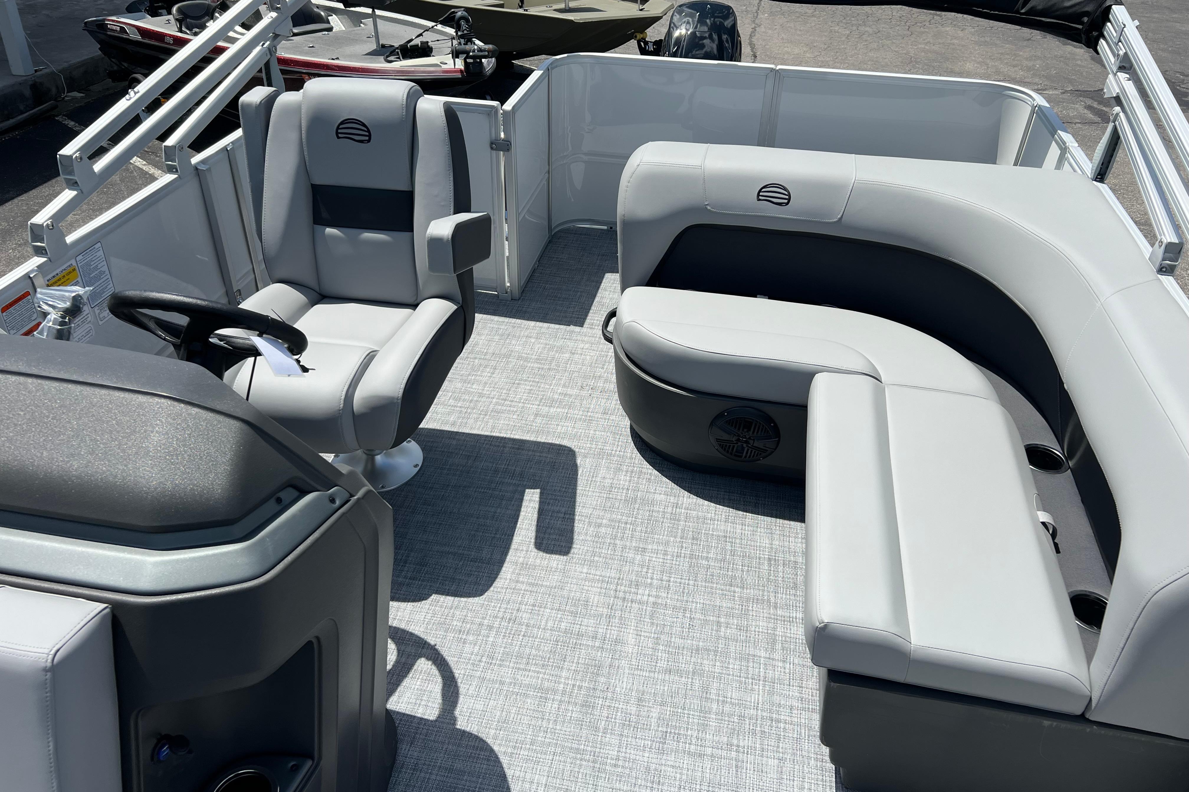 2026 Sun Tracker Party Barge 18 DLX interior with gray seating and steering console.