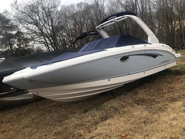 2019 Chaparral 264 Sunesta boat parked on dry grass.
