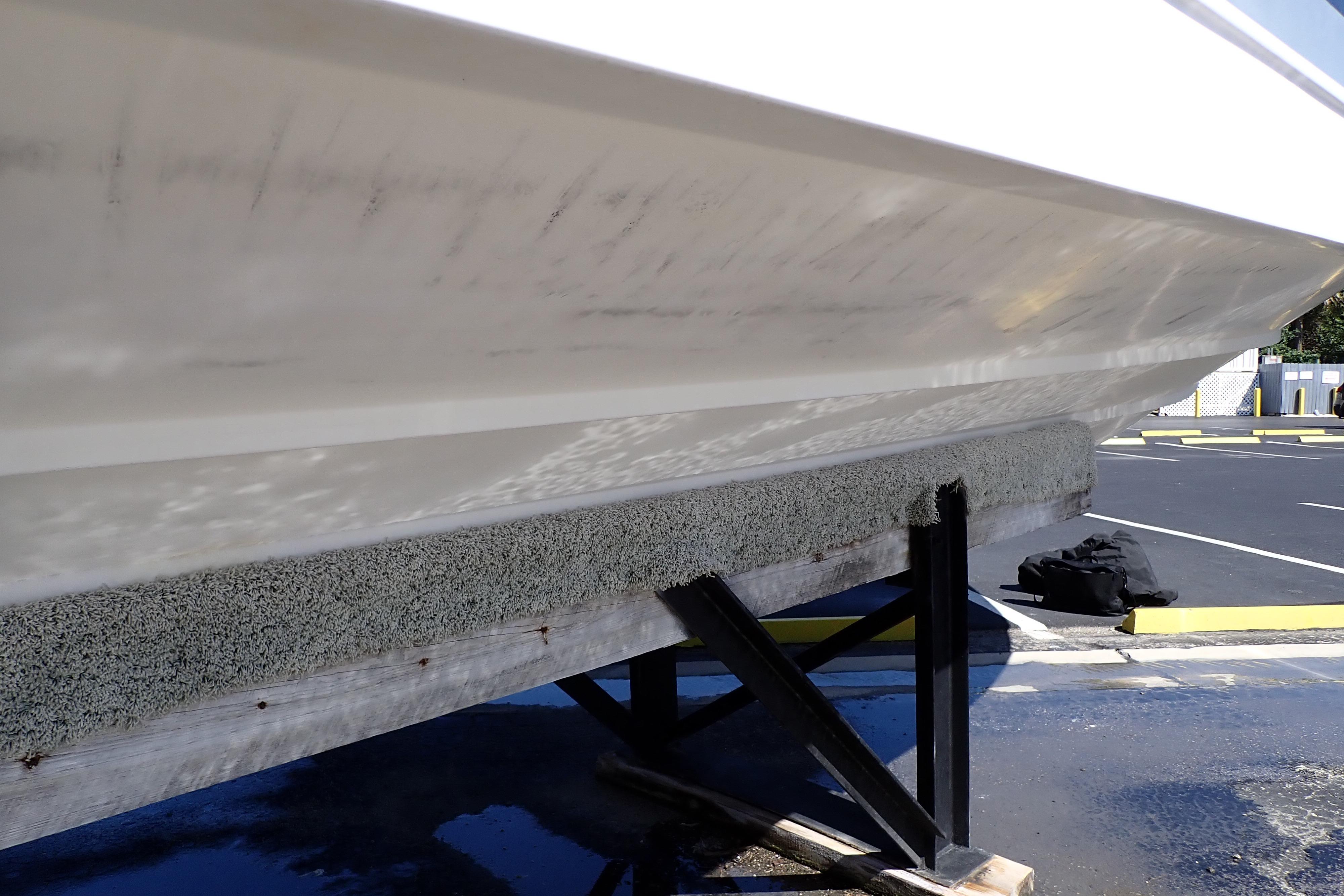2014 Pro-Line 32 Express boat hull on a trailer in a parking lot.