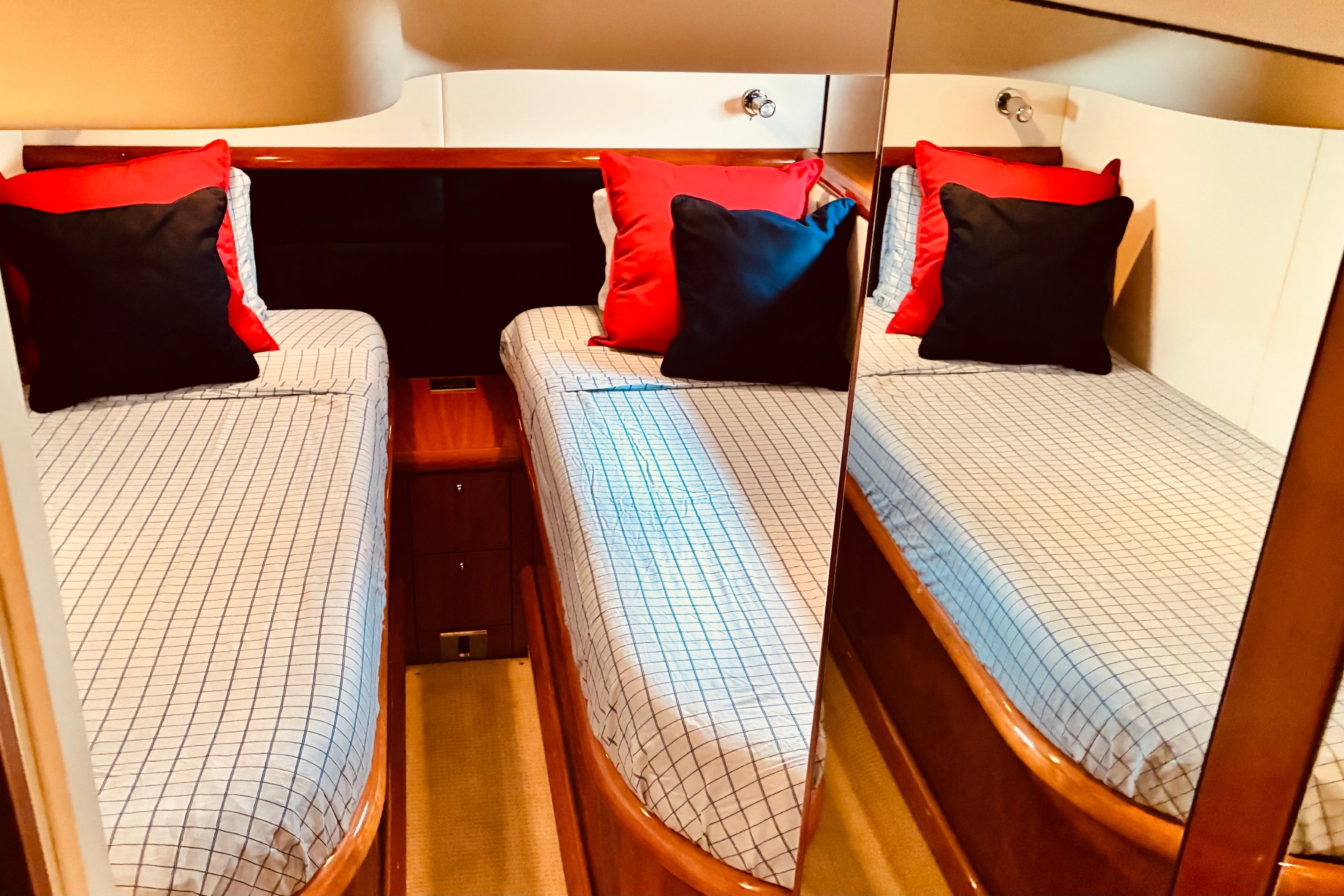 Luxurious twin cabin in 2003 Sunseeker Predator 61 yacht with stylish bedding and cushions.