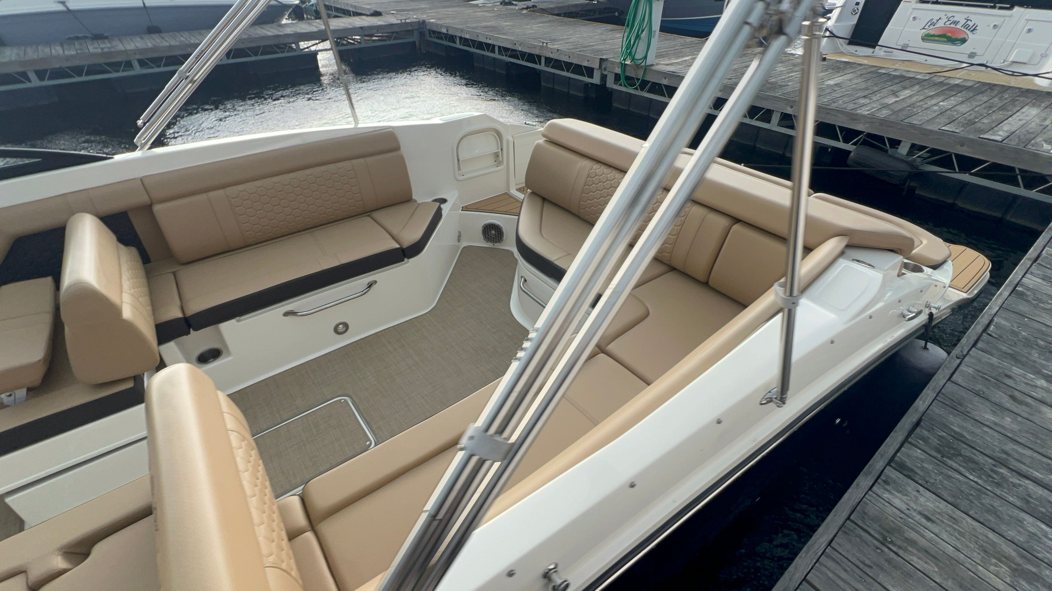 Interior of a 2018 Sea Ray SDX 270 with beige seating at the dock.