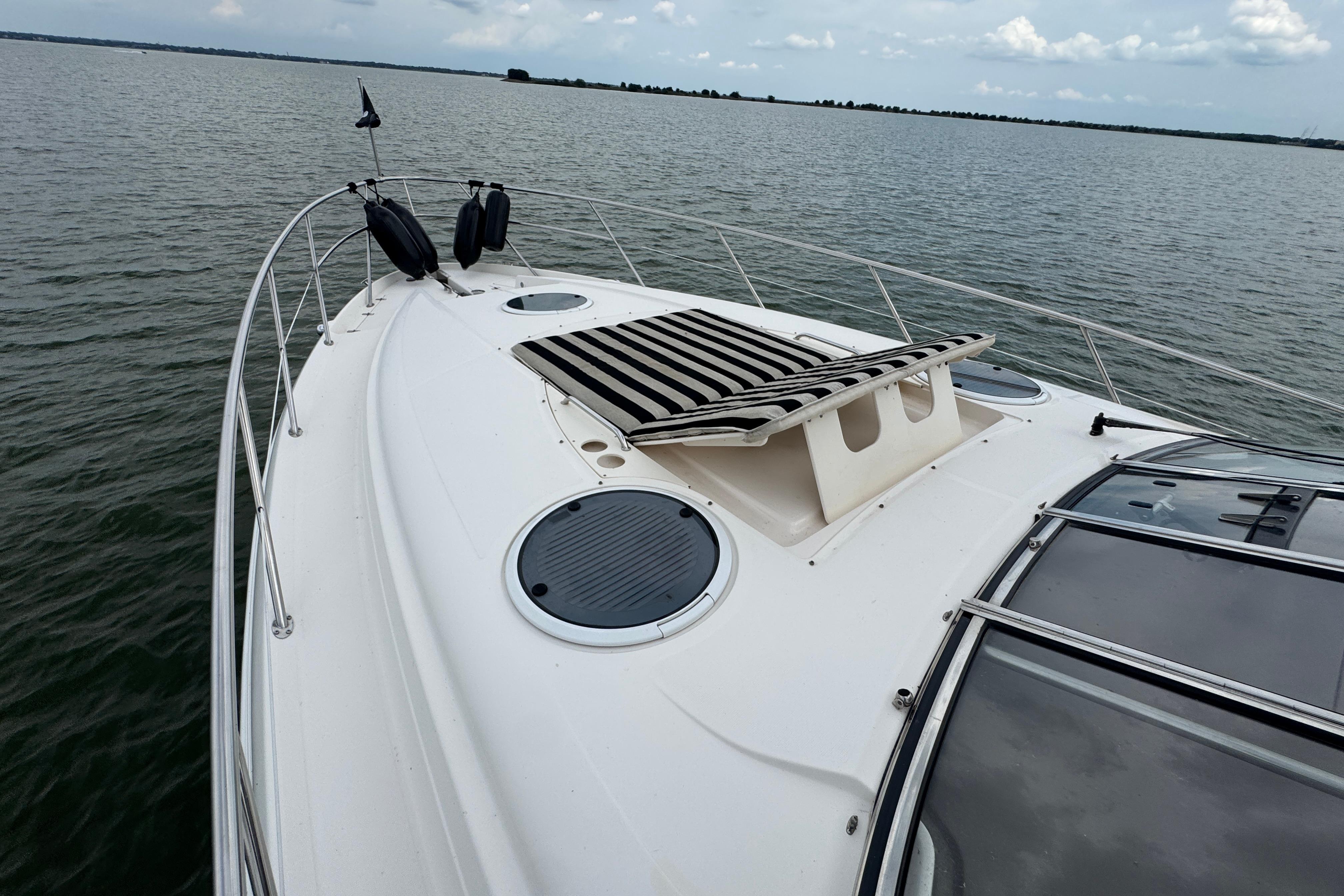 2005 Regal Commodore 4260 yacht on calm water, featuring sleek deck design.