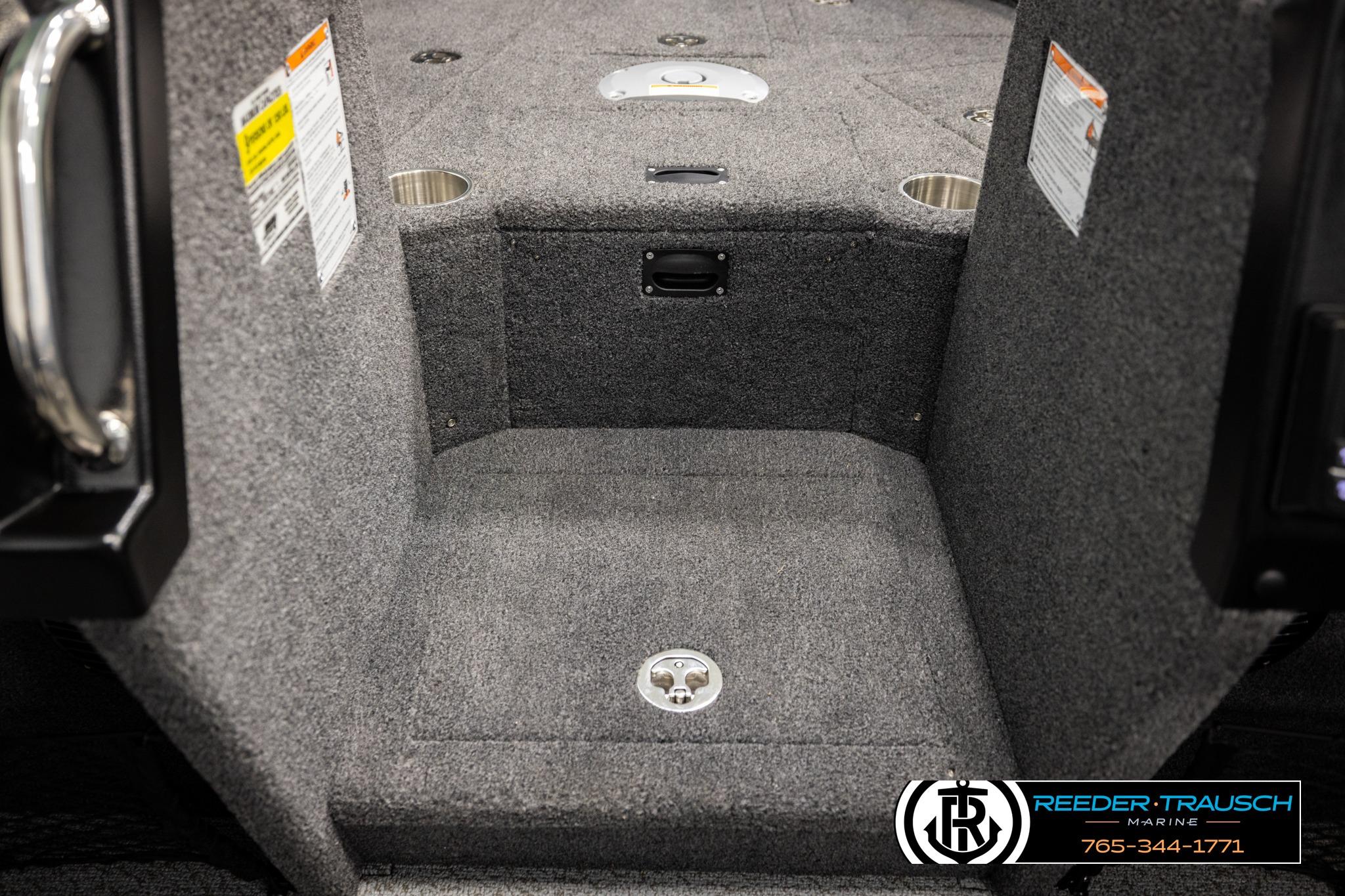 Interior of 2026 Lund 1975 Tyee boat with carpeted flooring and cup holders.