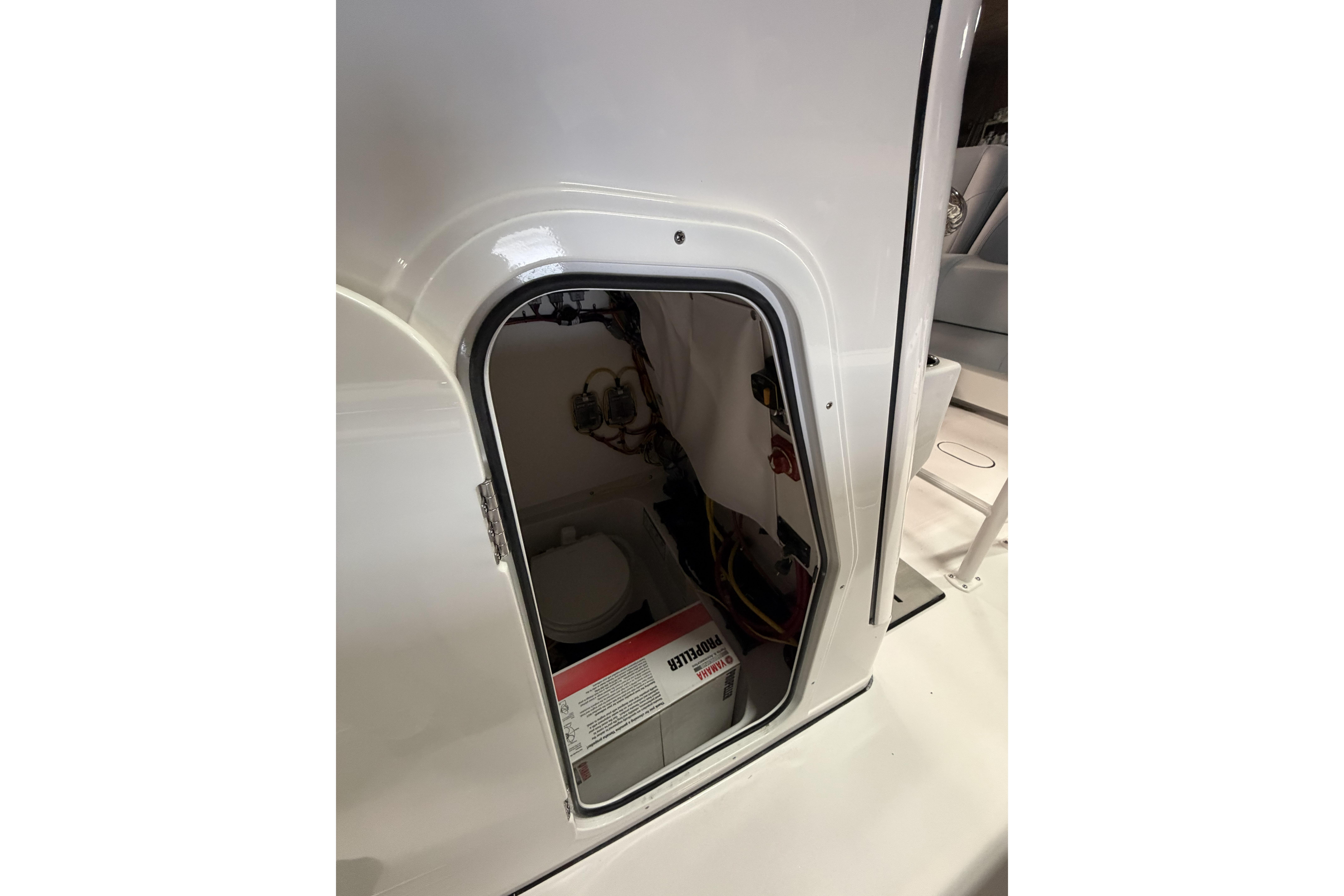 2026 Sportsman Open 232 Center Console storage compartment with battery and wiring.