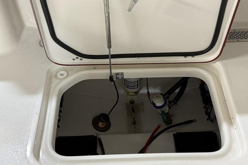 Open hatch of 2026 Sea Pro 242 Center Console boat, revealing internal components.