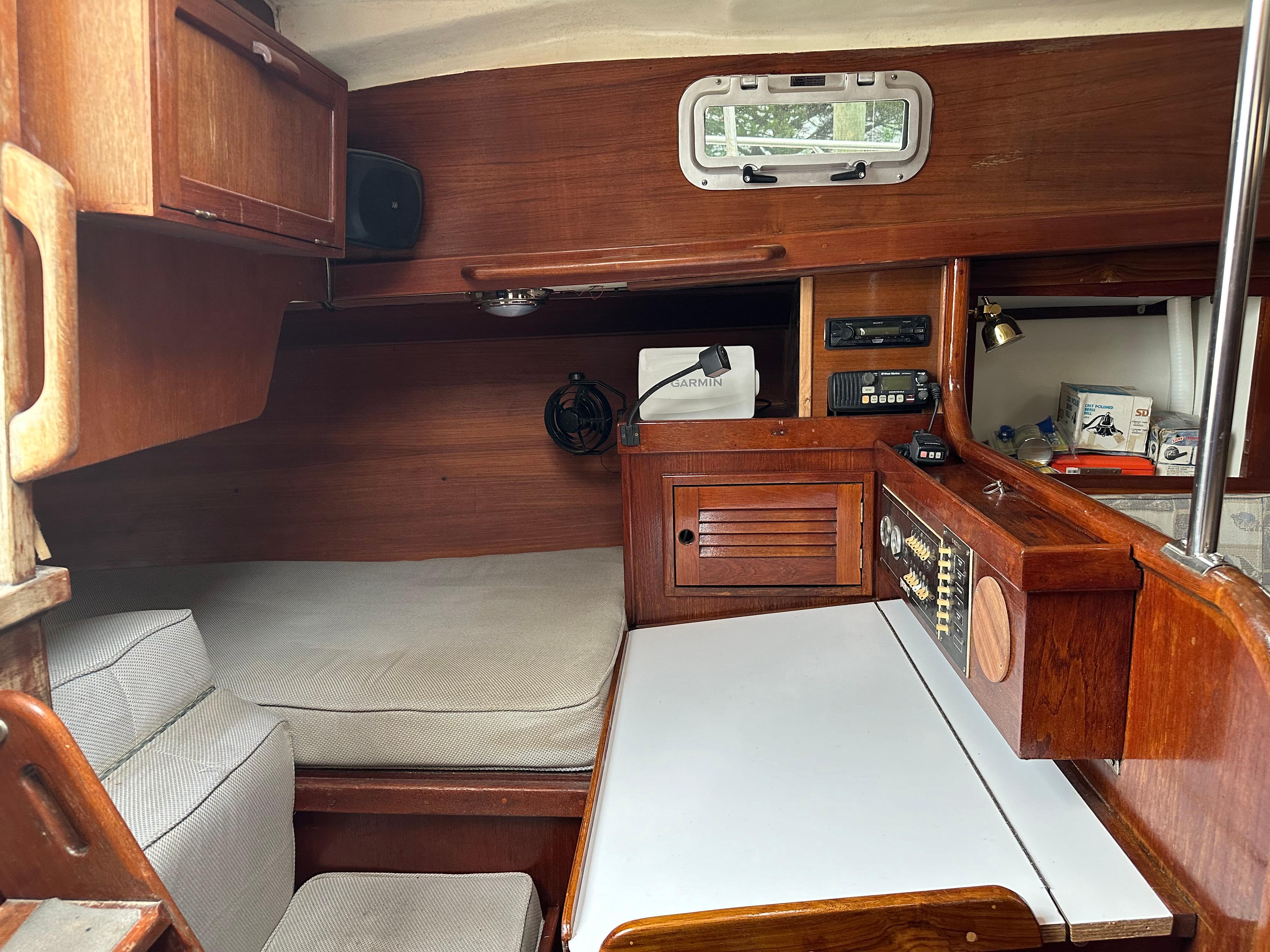 1981 Tartan 37 sloop interior with navigation station, wood cabinetry, and cushioned seating.
