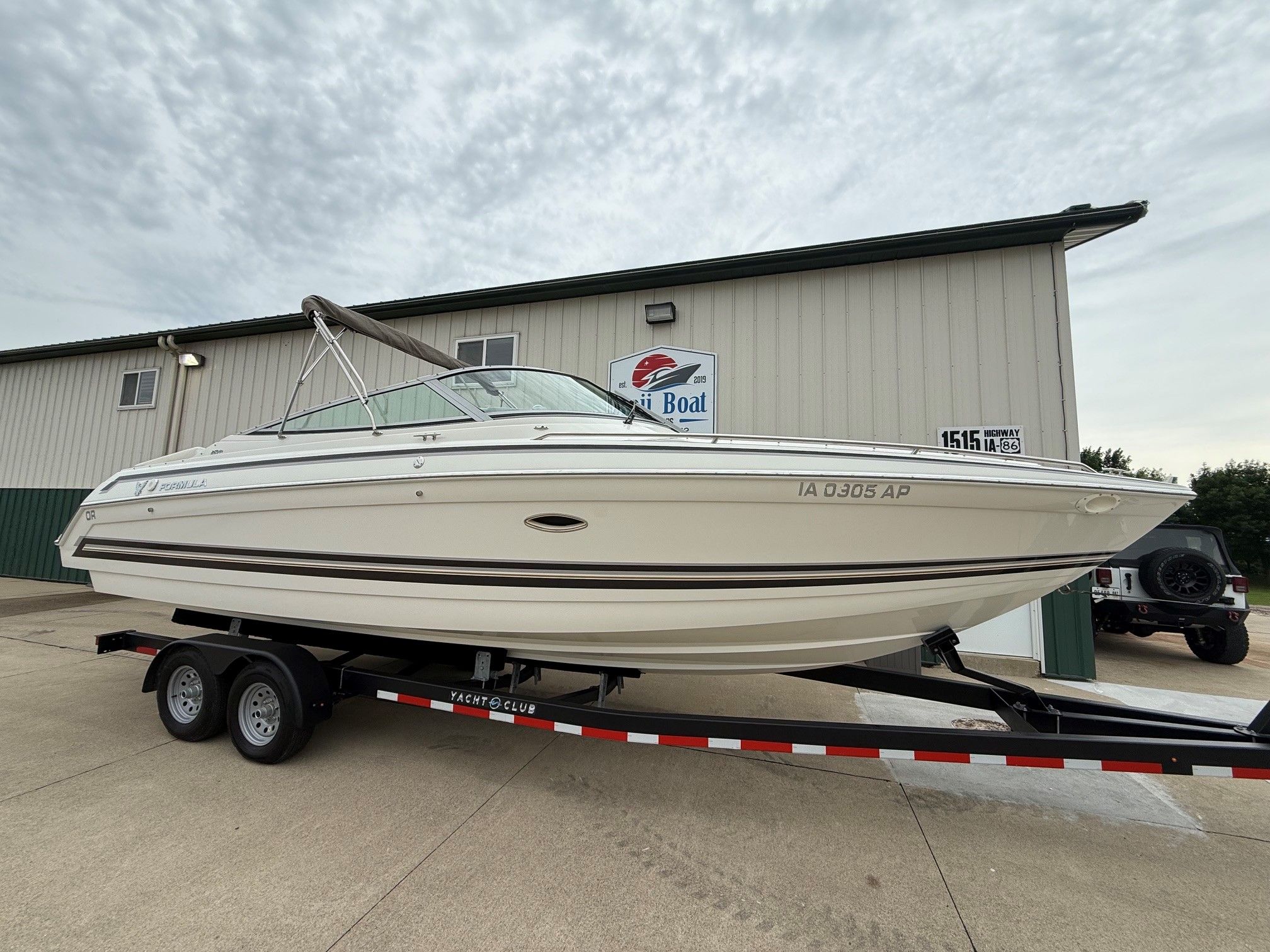 1998 Formula Thunderbird boat on trailer outside warehouse.