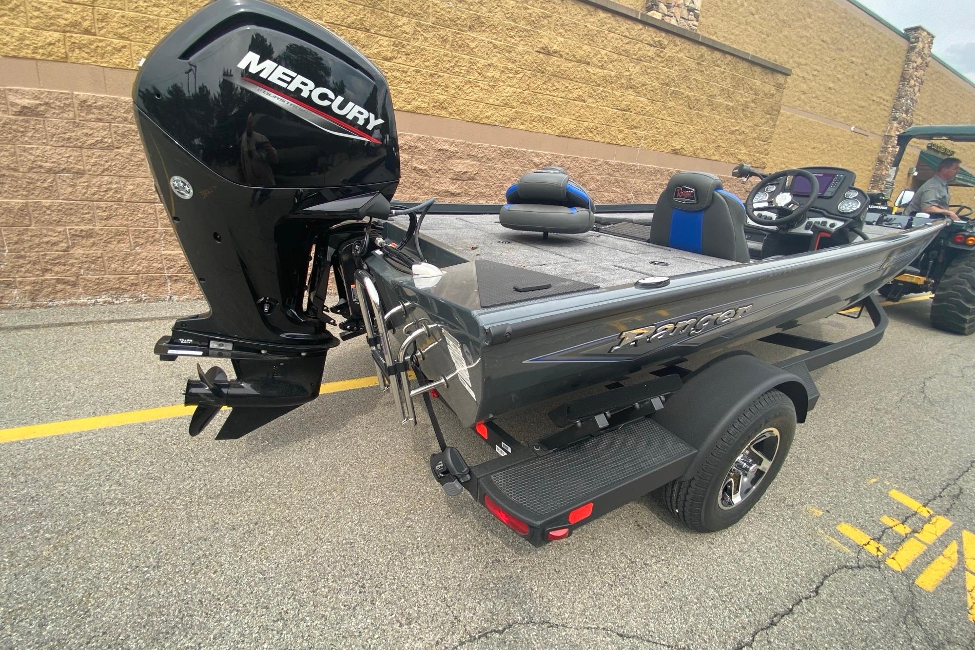 2026 Ranger RT178 boat with Mercury engine, parked on pavement near a building.
