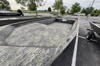 2026 Tracker Grizzly 1860 Utility boat in parking lot, showcasing rugged design.
