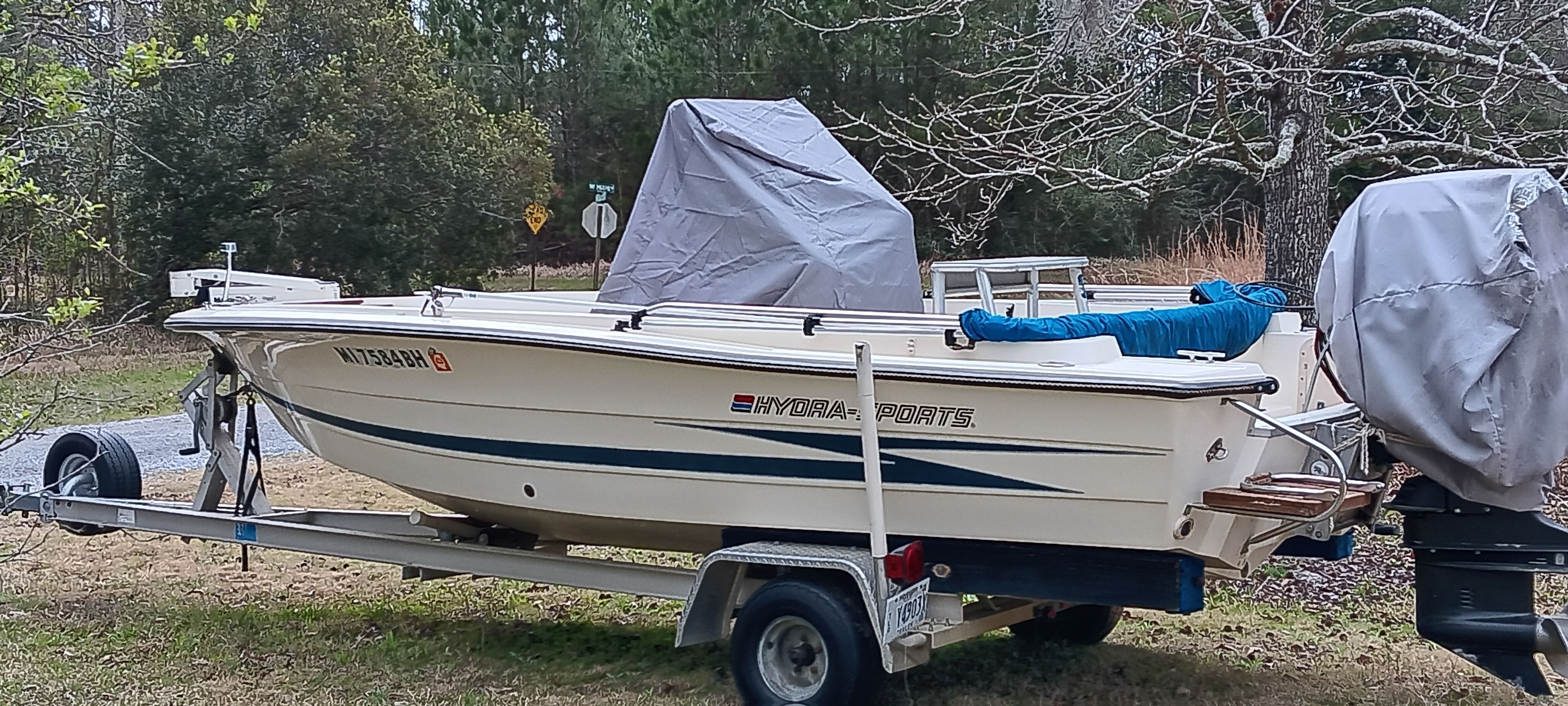 A 1990 Hydra-Sports Vector boat on a trailer in a wooded area.