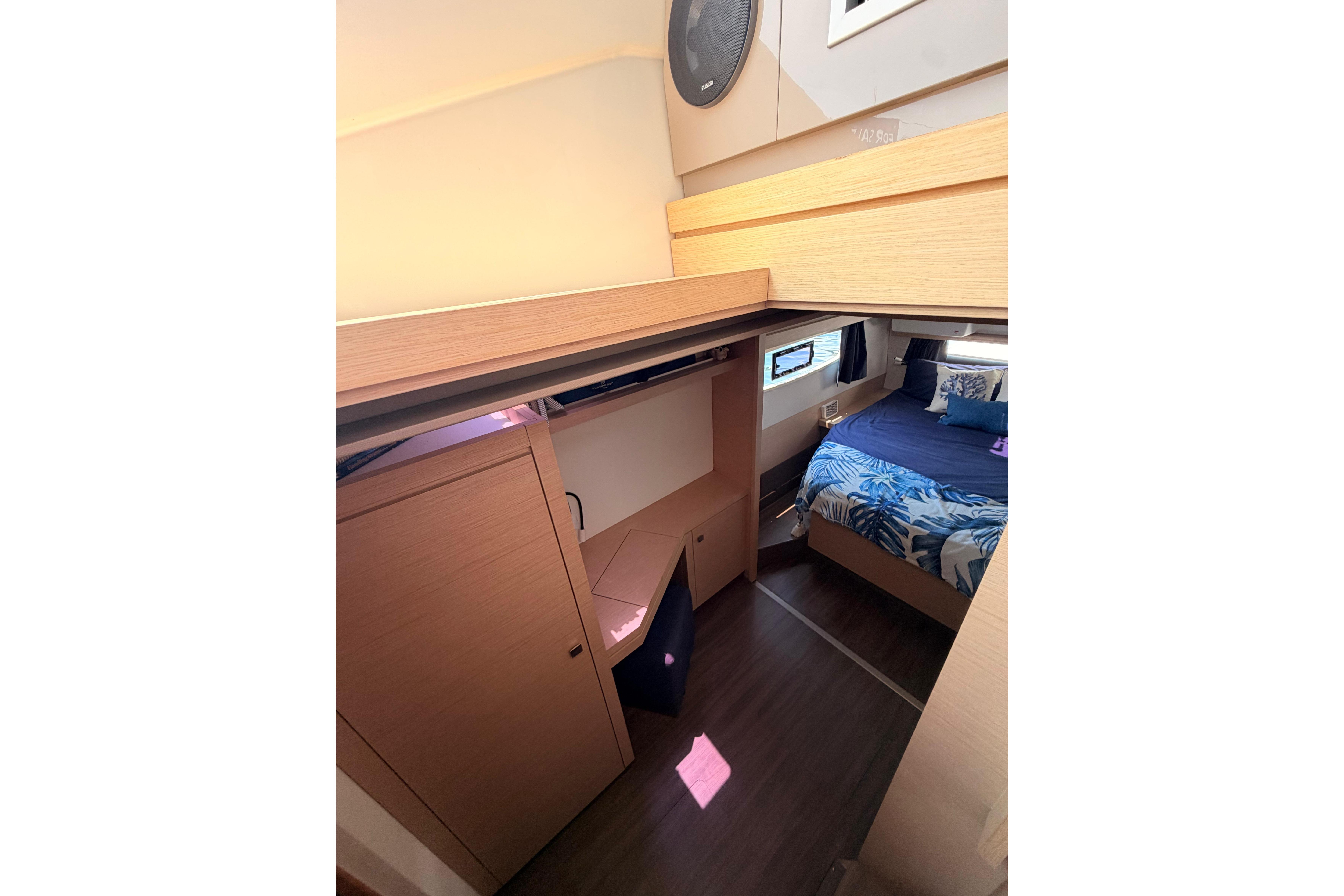 Interior cabin of 2018 Fountaine Pajot Lucia 40 catamaran, featuring a cozy bed and wooden furnishings.