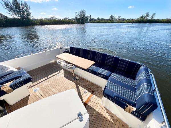 2025 Sabre 43 Salon Express boat with blue-striped seating on a sunny lake.