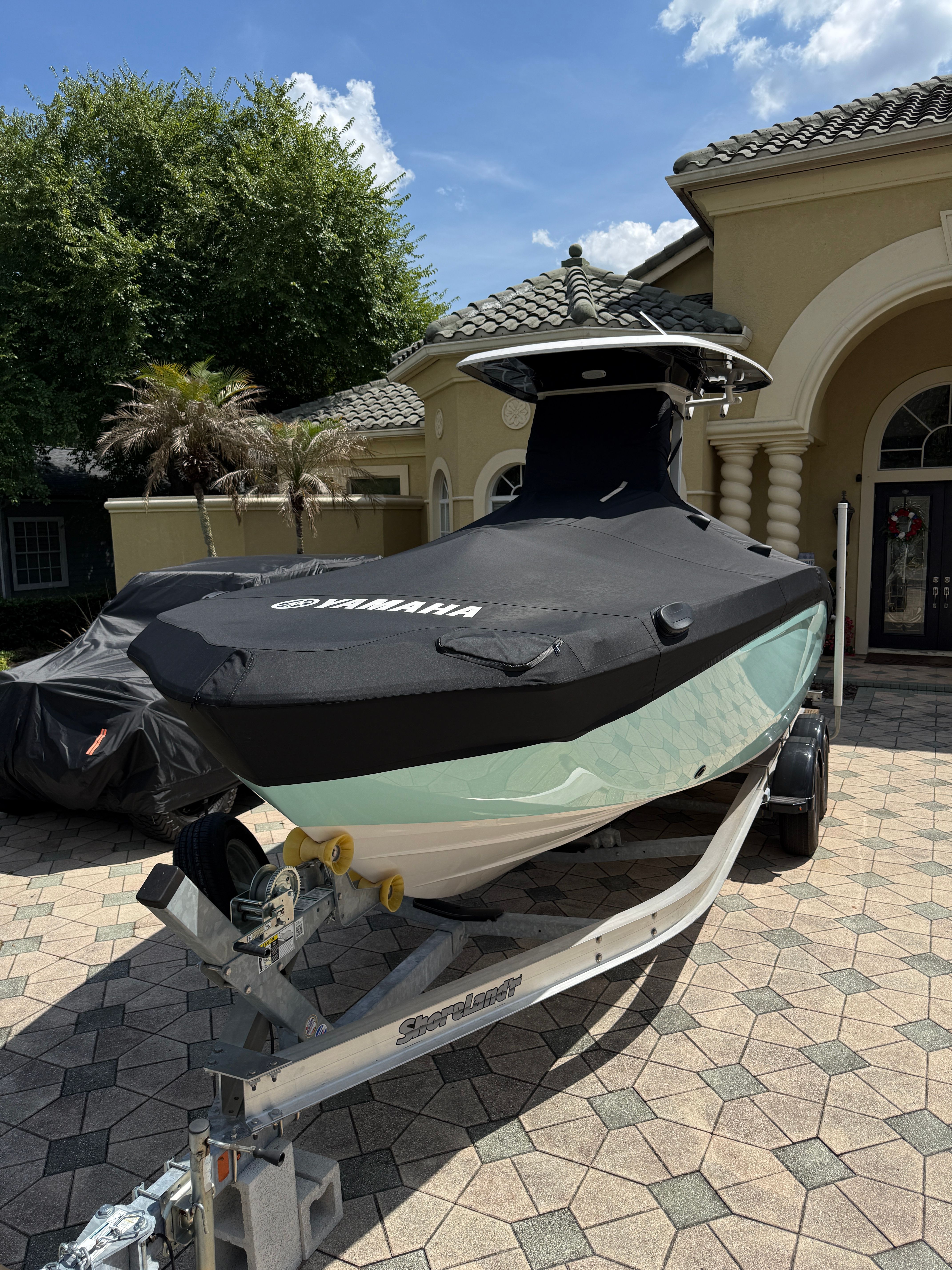 Yamaha 252 FSH Sport 2024 on a trailer in front of a house with palm trees.