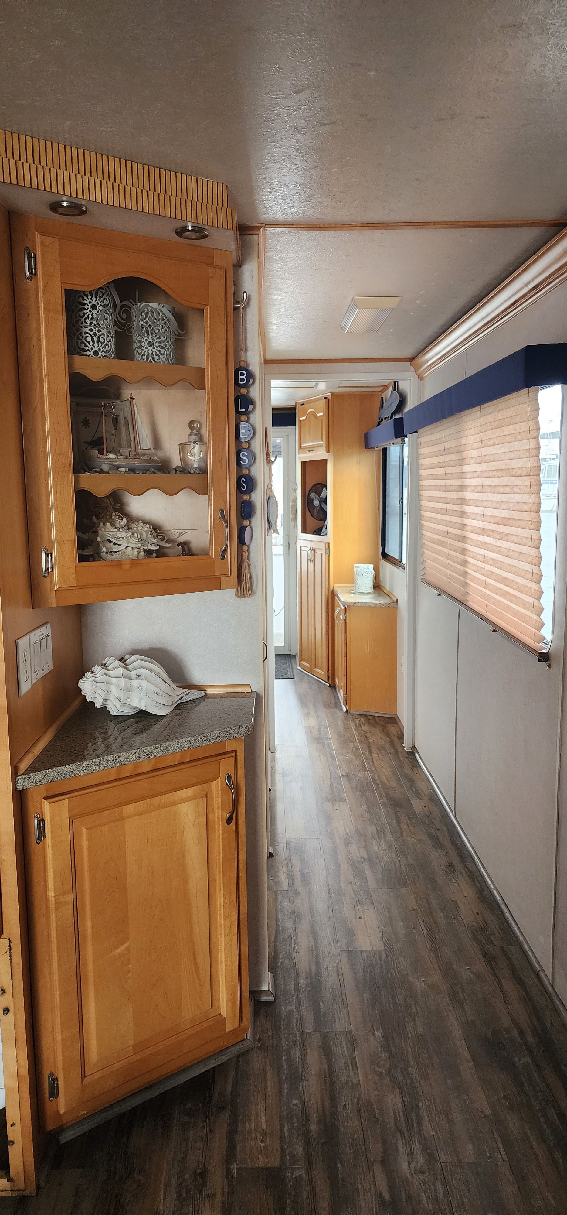 Interior of a houseboat with wooden floors and cabinets.