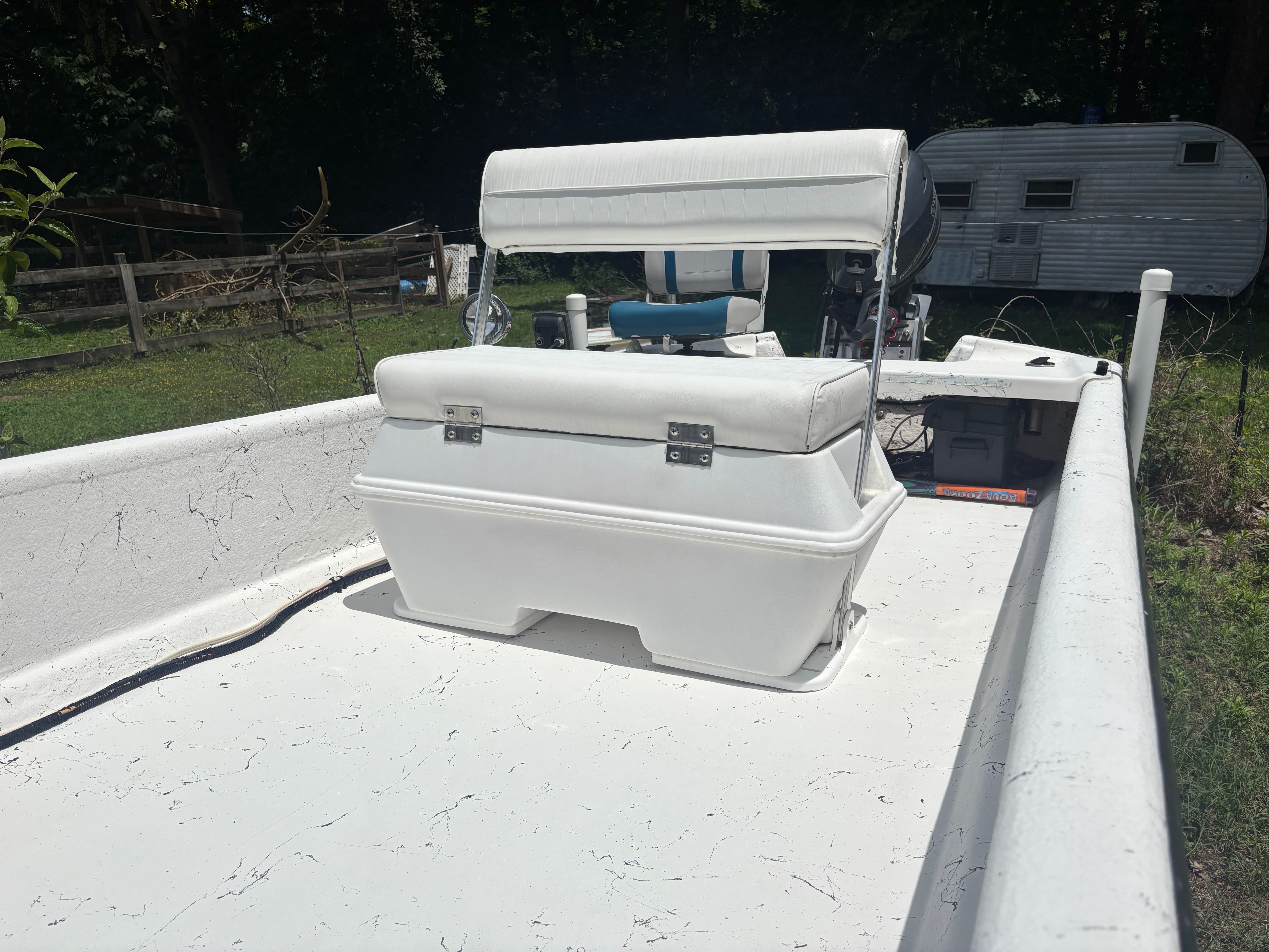 A 2004 Carolina Skiff J16 with a white seat and console, parked outdoors.