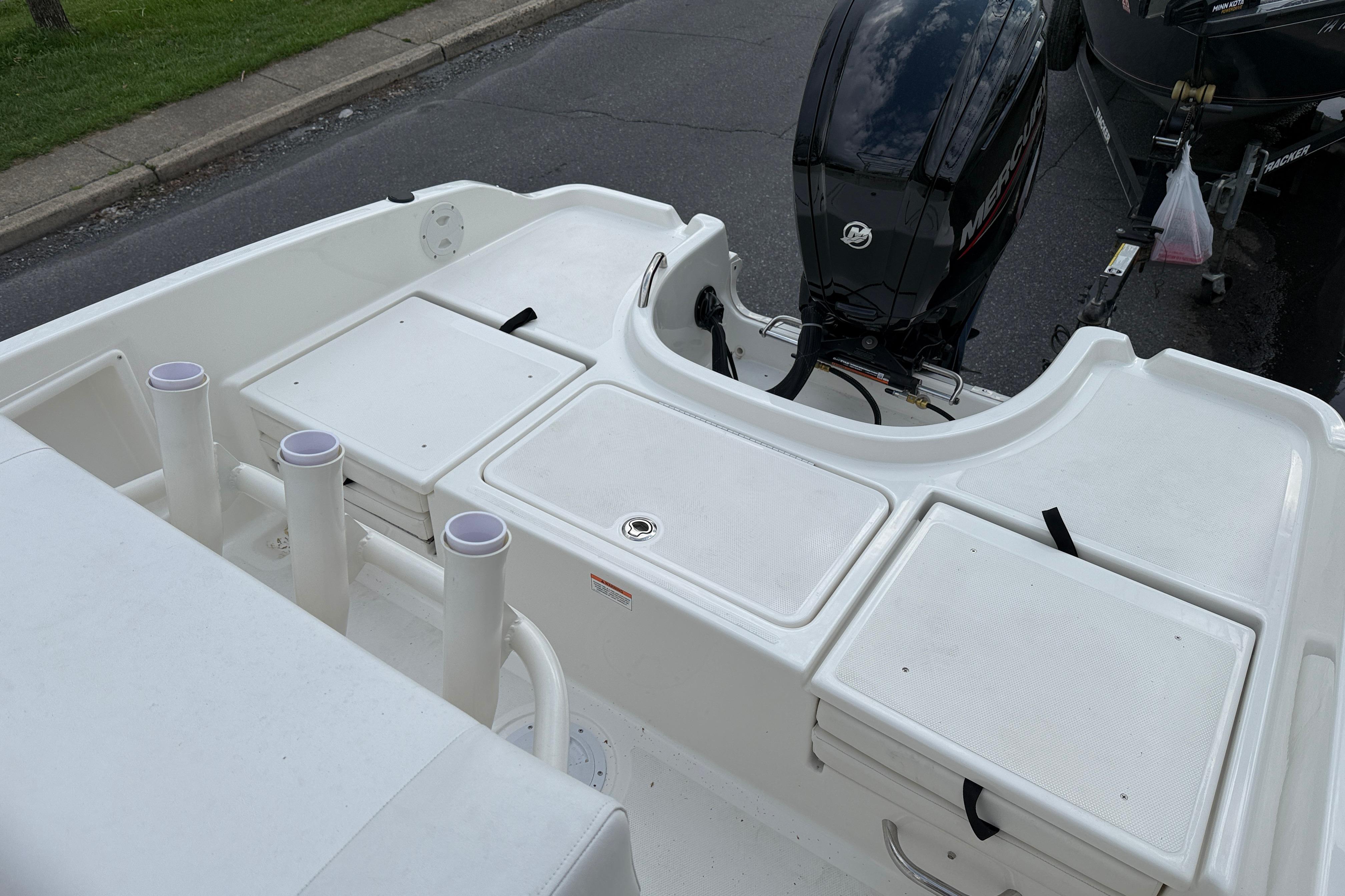 2026 Bayliner Trophy T18 boat deck with storage compartments and Mercury outboard motor.