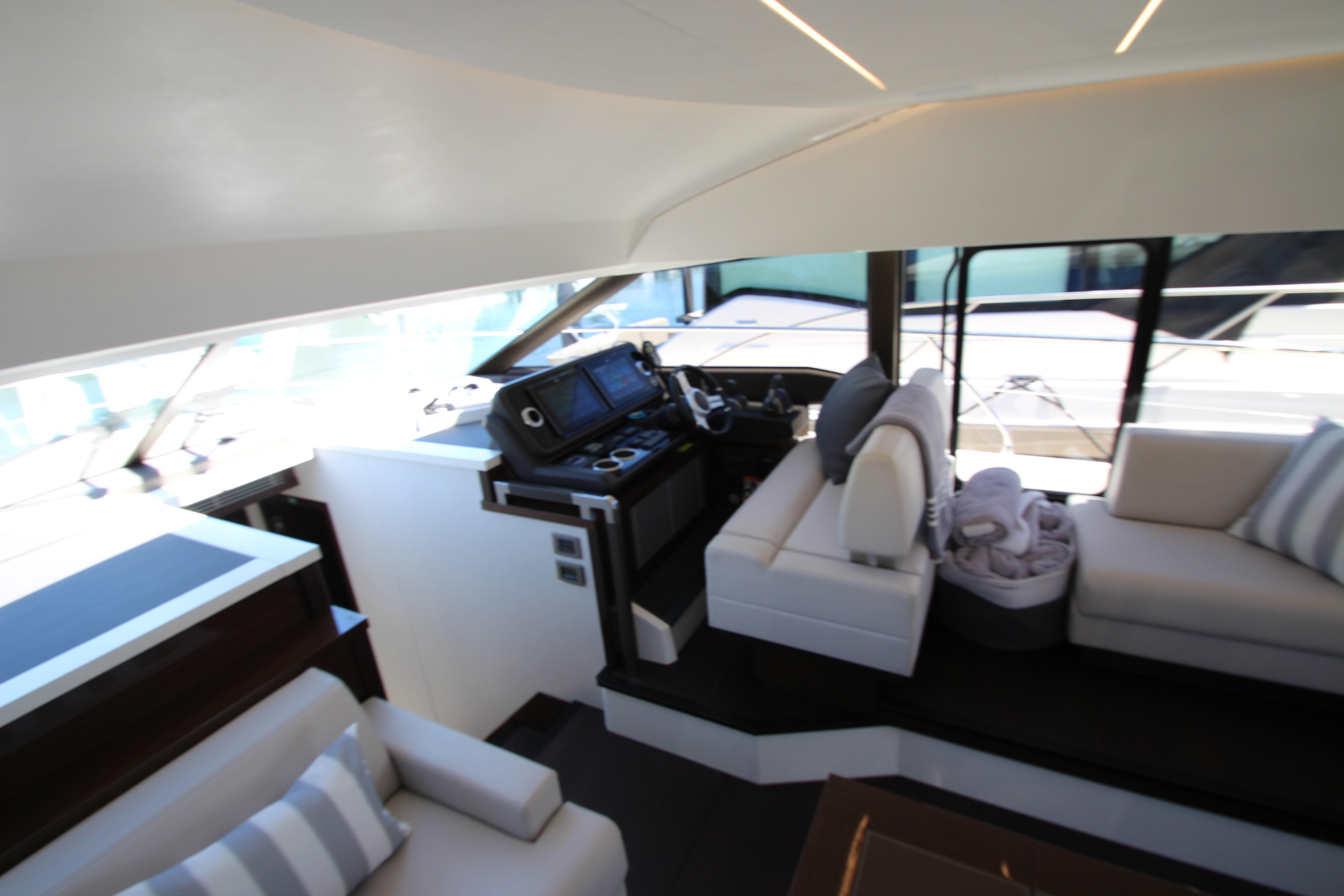 Luxurious interior of 2022 Prestige 520 yacht with modern helm and seating area.