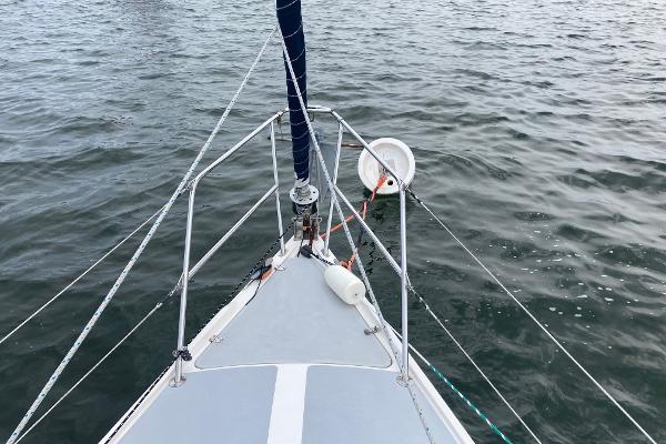 Bow of 1989 Catalina 30 sailboat on water, featuring rigging and deck details.