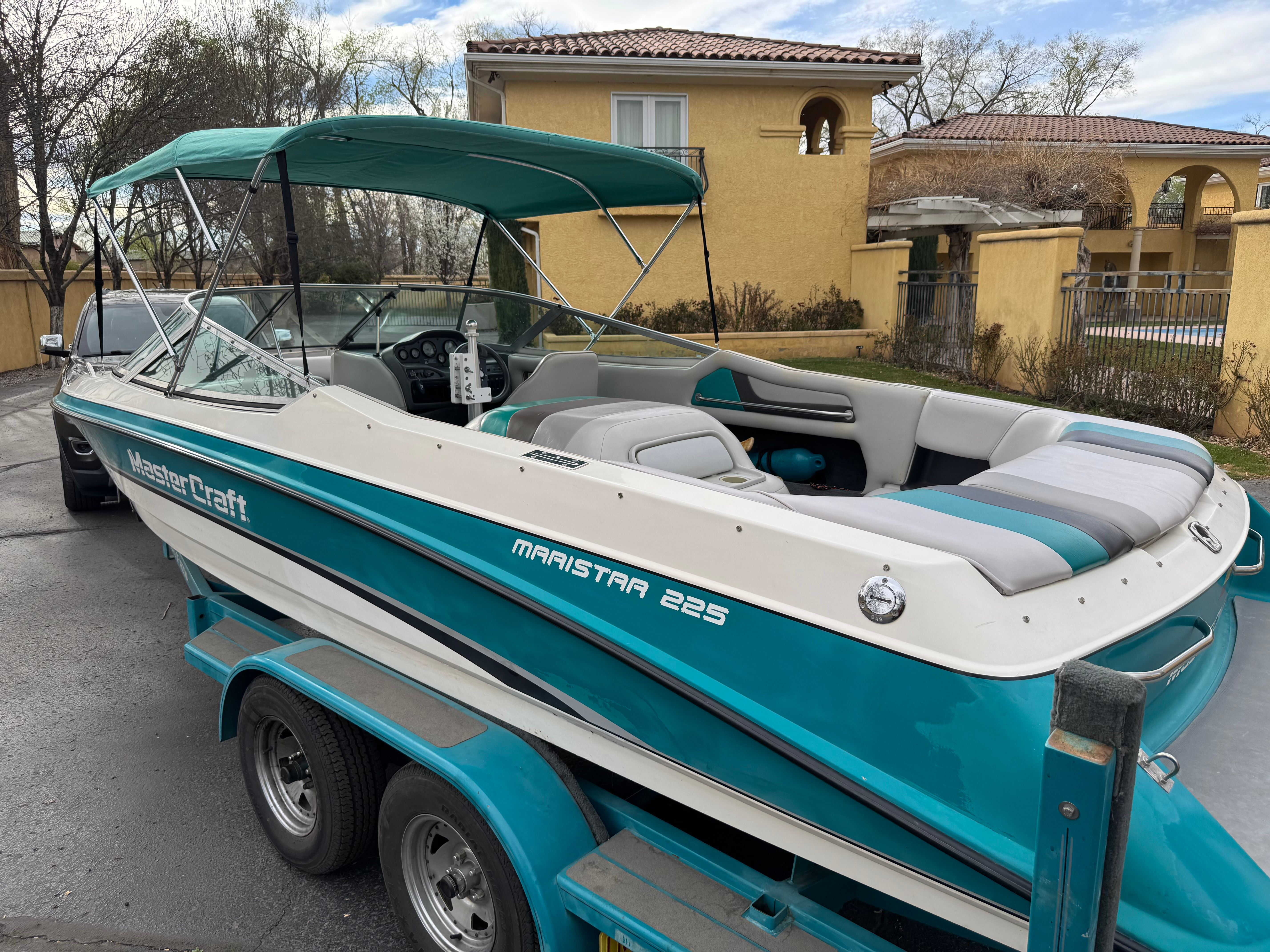 1993 MasterCraft Maristar boat on trailer in front of house.