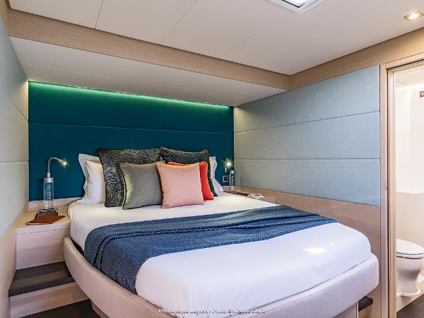 Luxurious bedroom interior of 2025 Lagoon 55 yacht with modern design and cozy bedding.