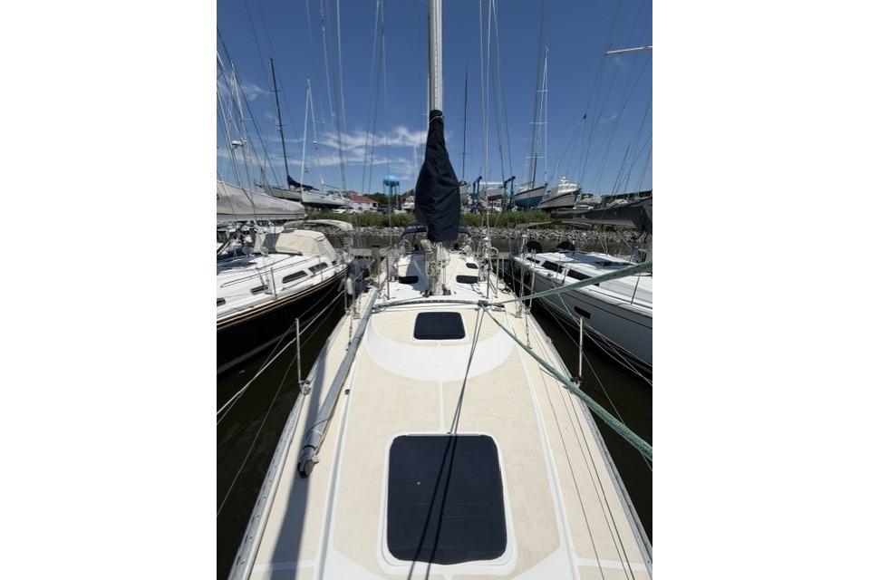 2002 Saga 43 sailboat docked, view of deck and mast under clear blue sky.
