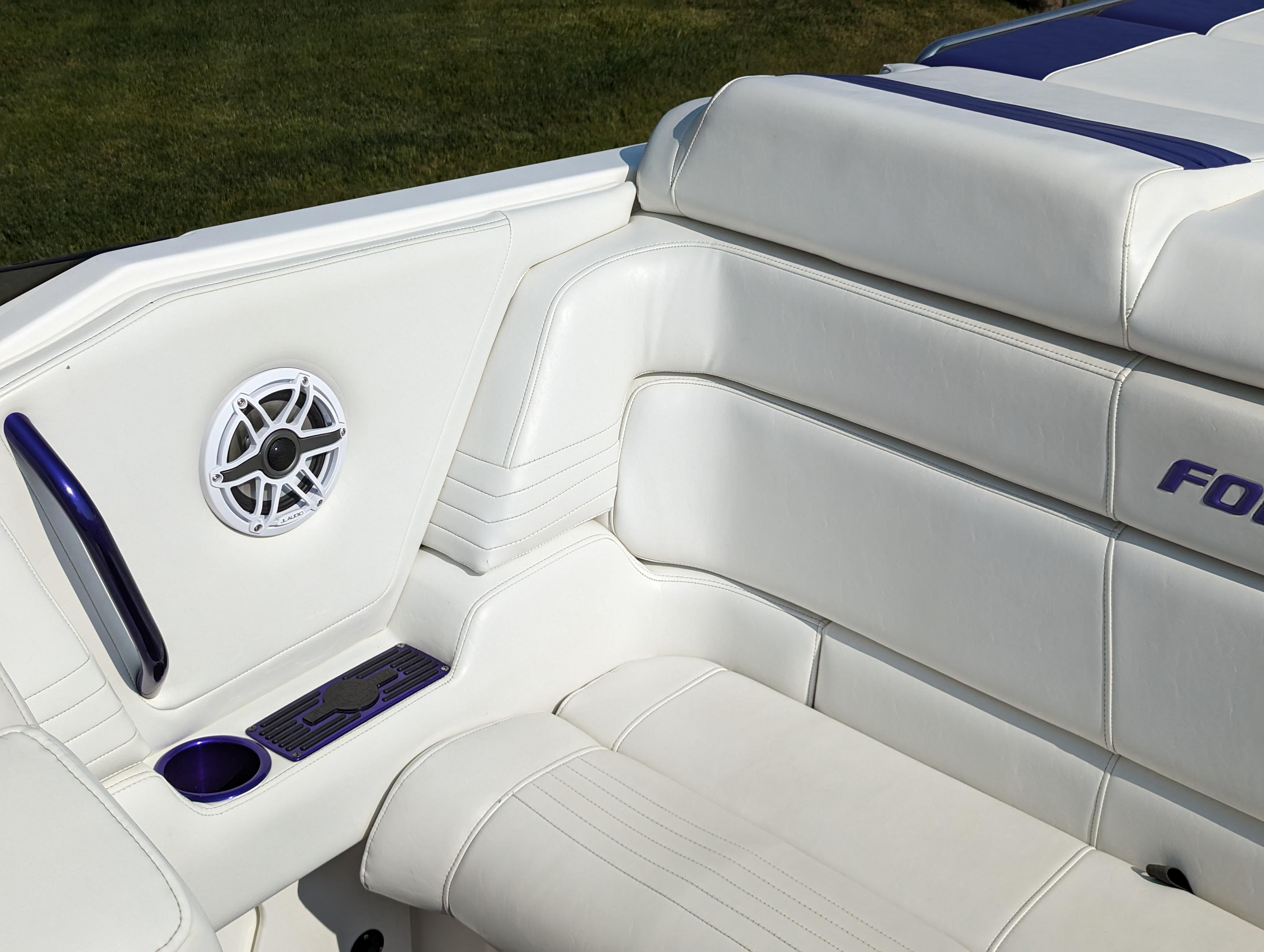 White and blue seating on a 2006 Fountain 42 boat with speaker and cup holder.